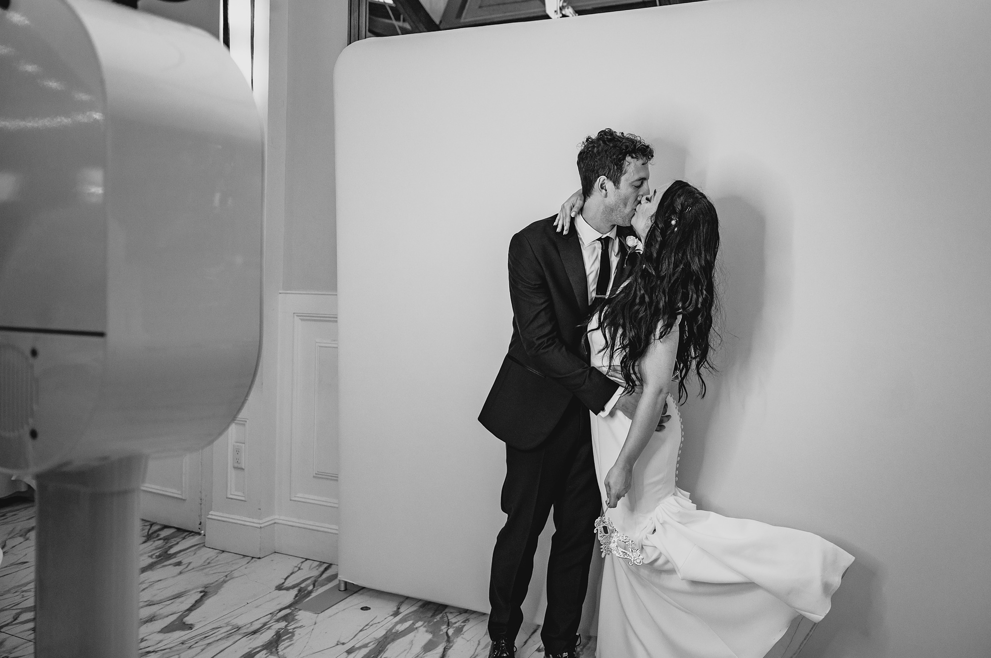 newlyweds kiss in photo booth at wedding reception