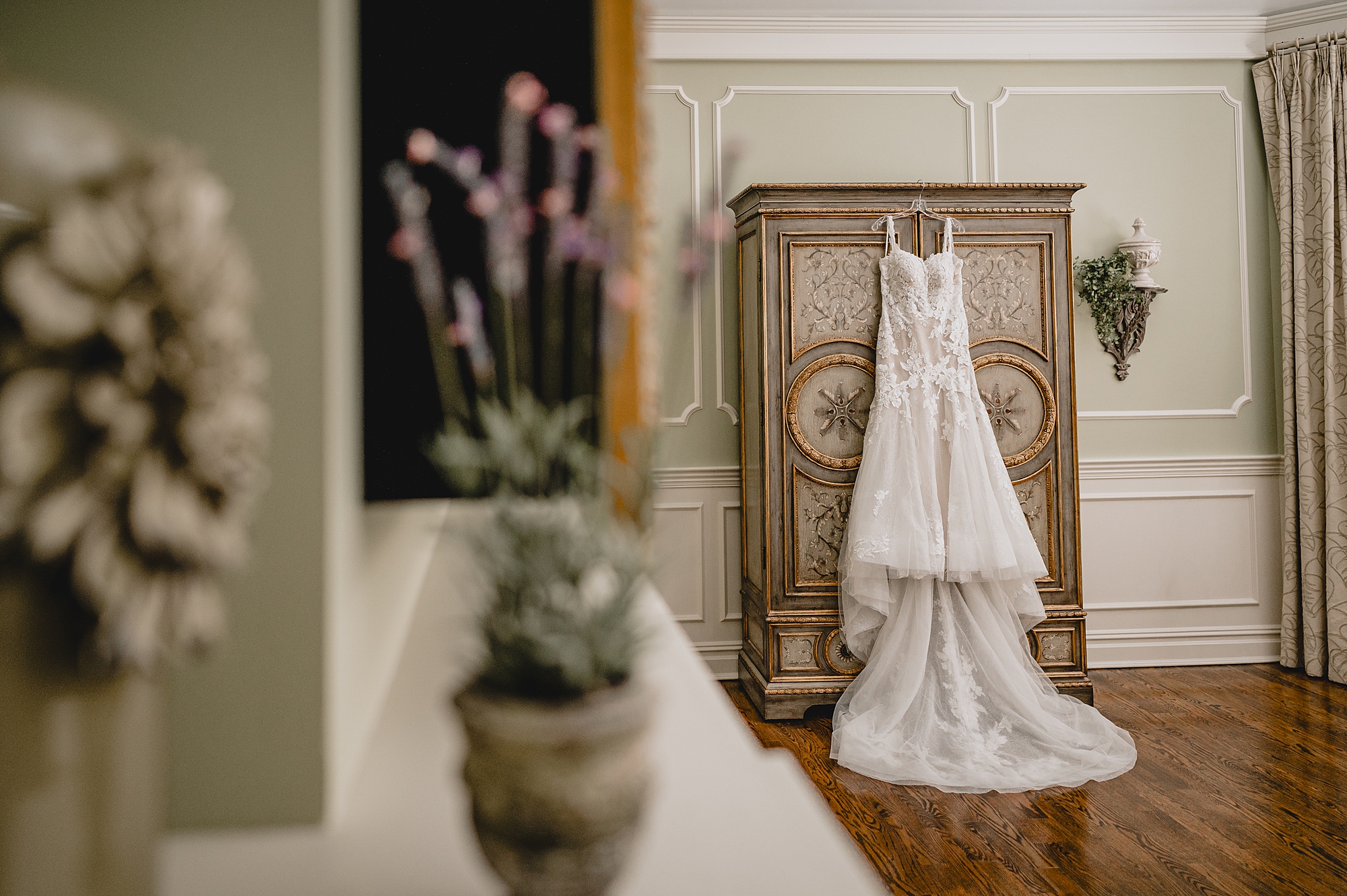 wedding dress hangs on bureau in bridal suite