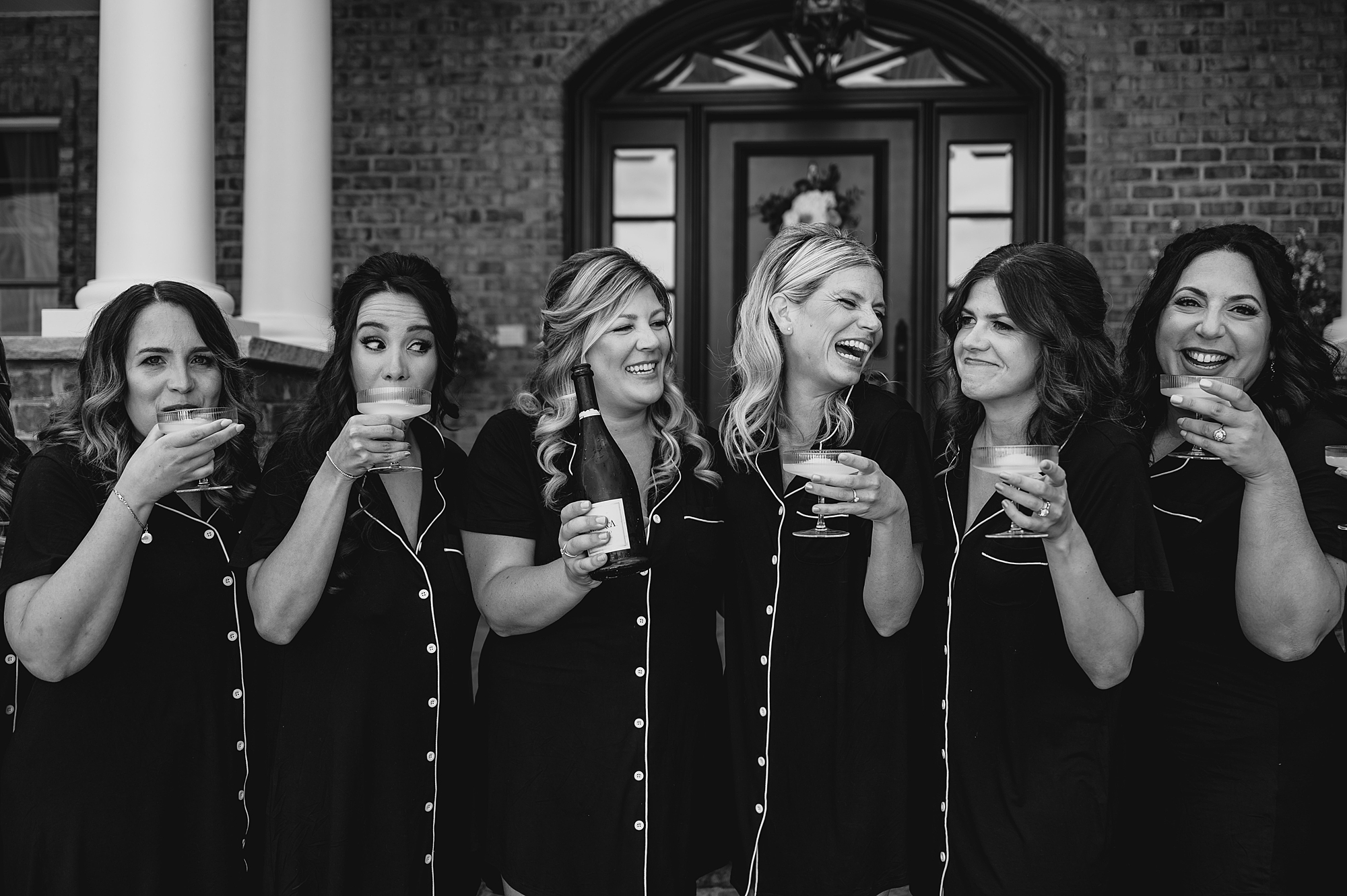bridesmaids and bride laugh in matching pajamas during prep at the Mill Lakeside Manor