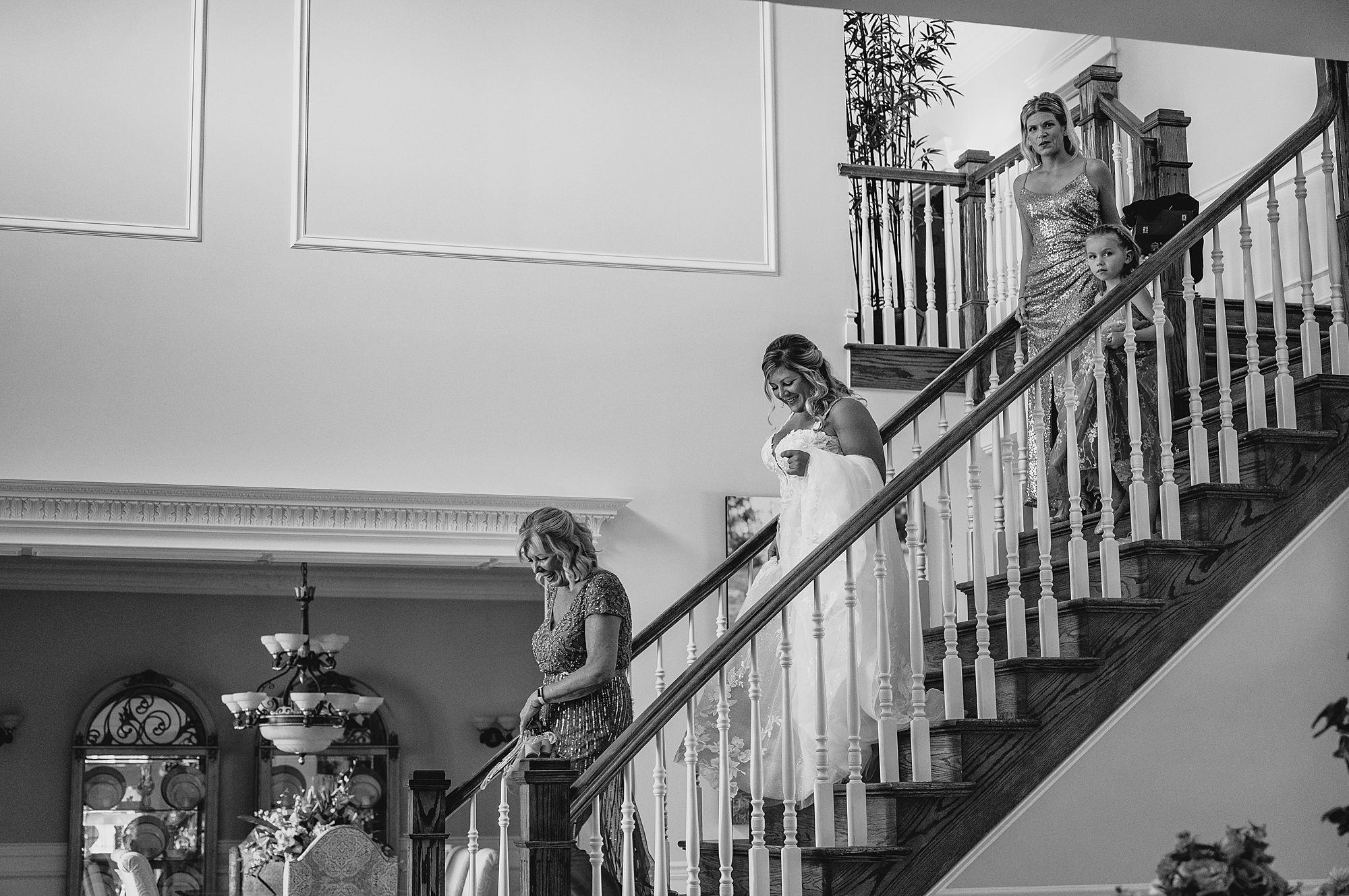 bridesmaids help bride down staircase inside the Mill Lakeside Manor