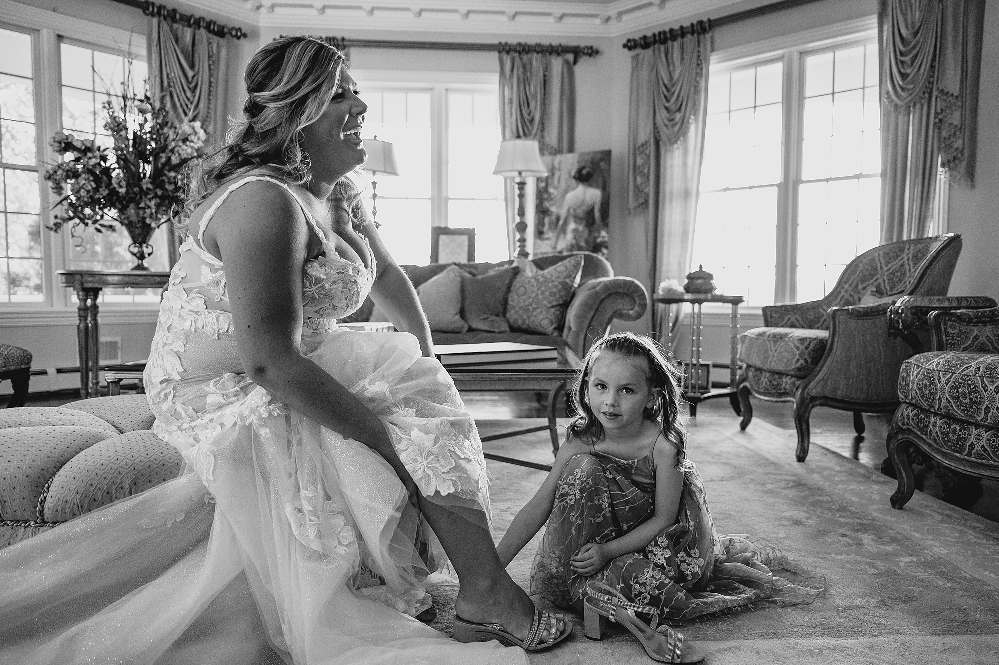 flower girl helps bride with shoes before New Jersey wedding