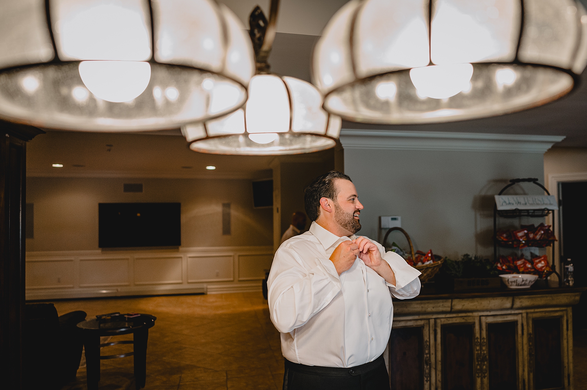 groom adjusts bowtie and shirt buttons