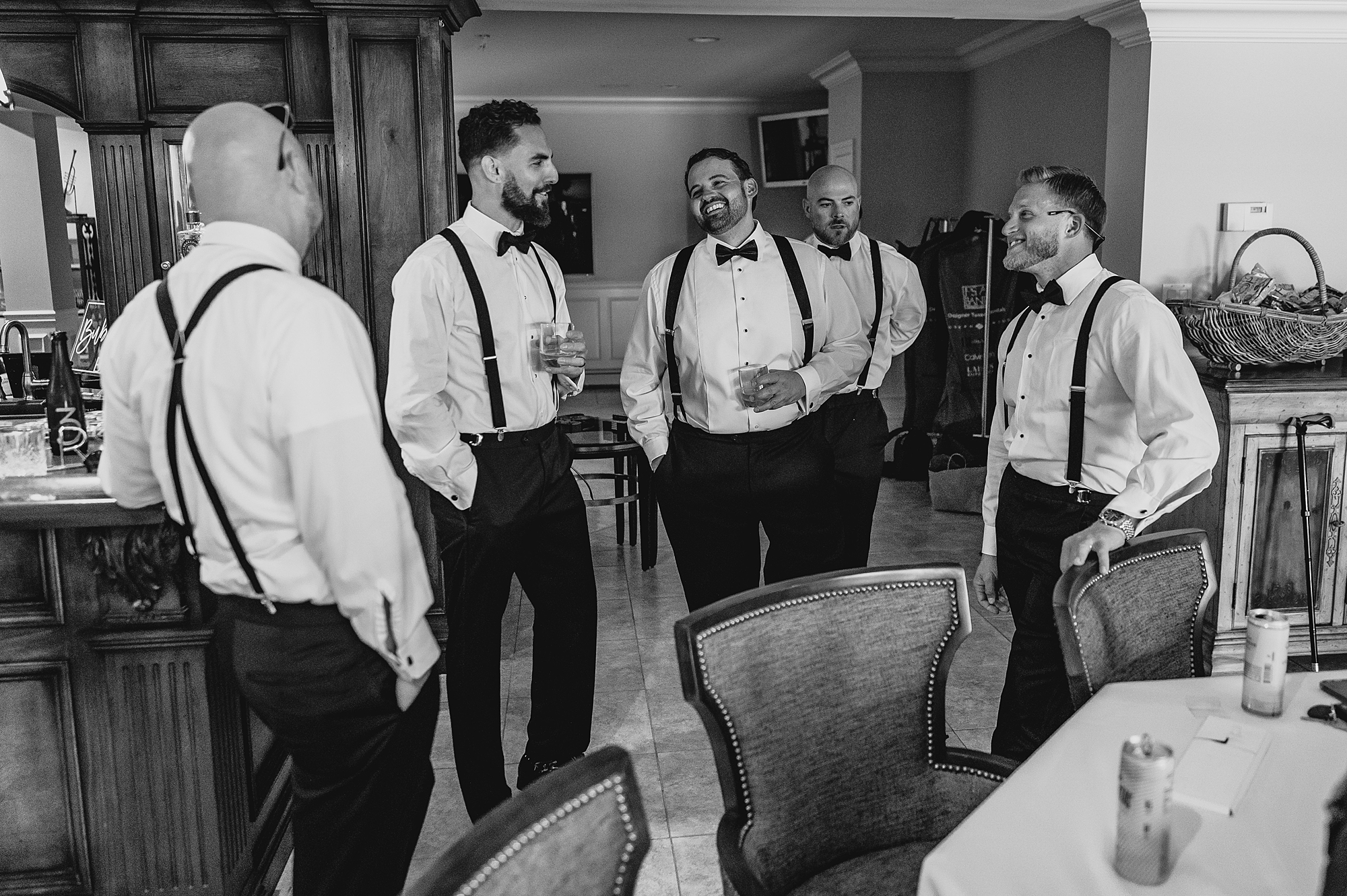 groom laughs with groomsmen during prep at the Mill Lakeside Manor