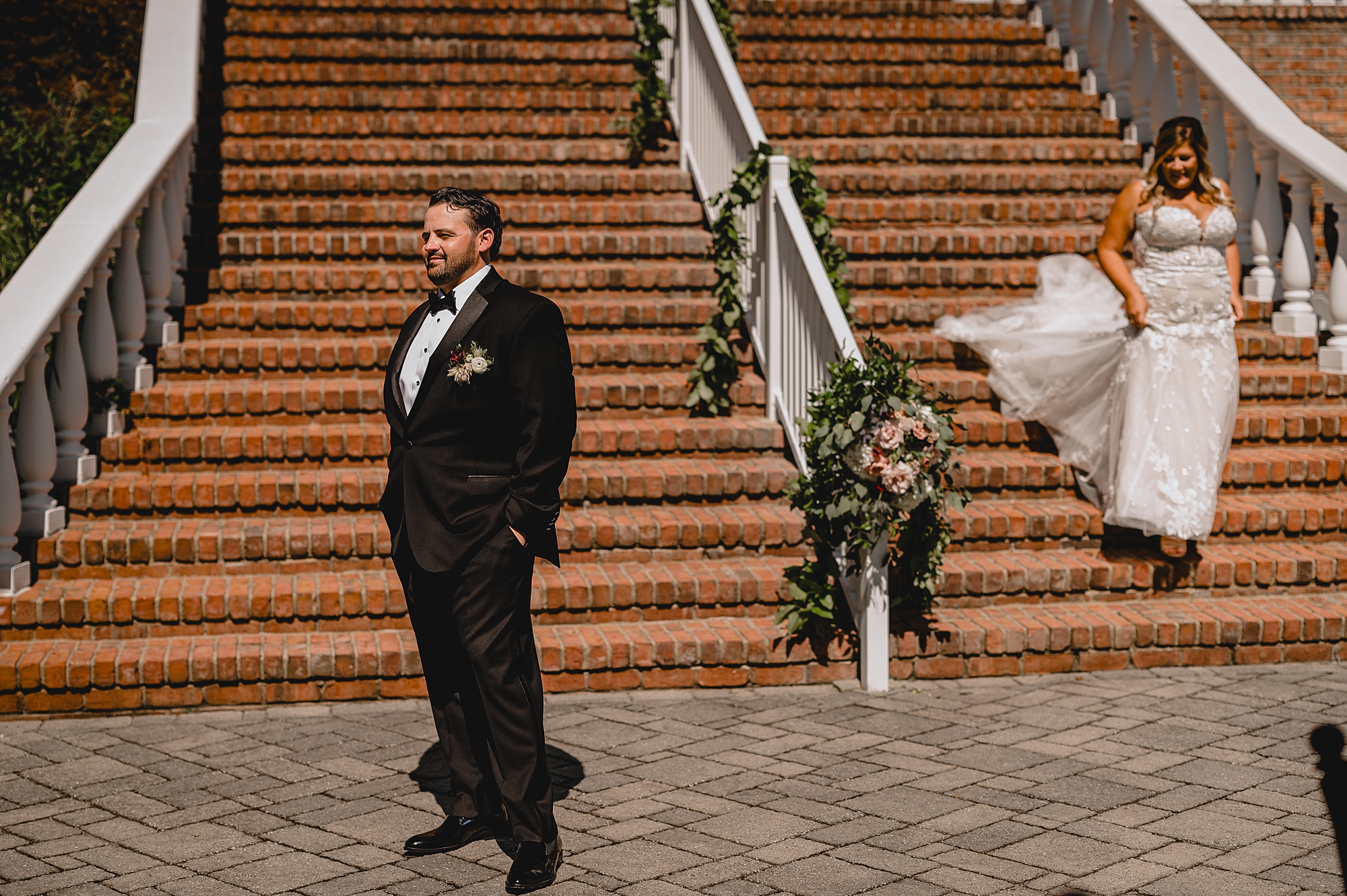 bride walks down staircase at the Mill Lakeside Manor to meet groom