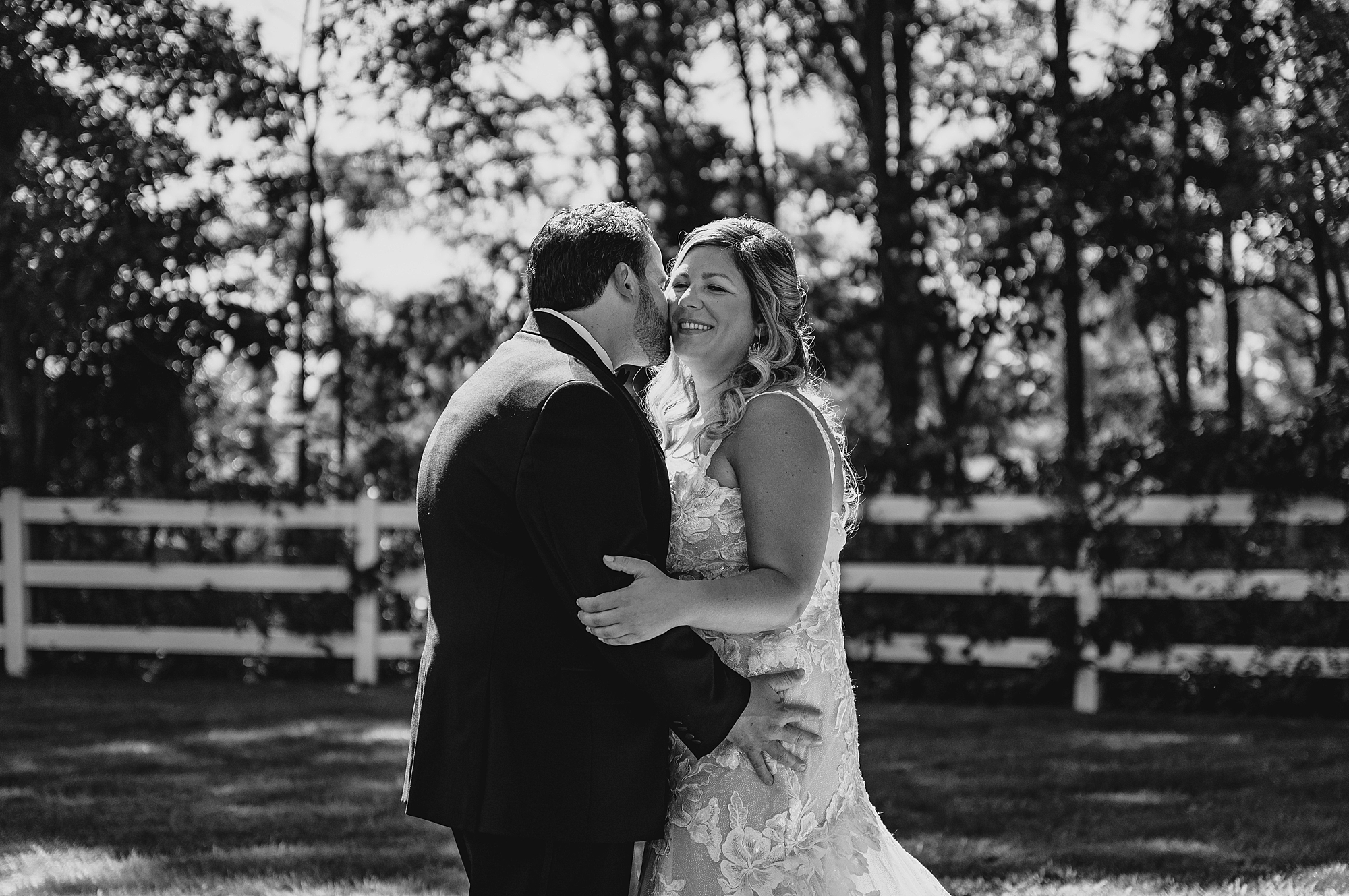 groom kisses bride's cheek during portraits at the Mill Lakeside Manor
