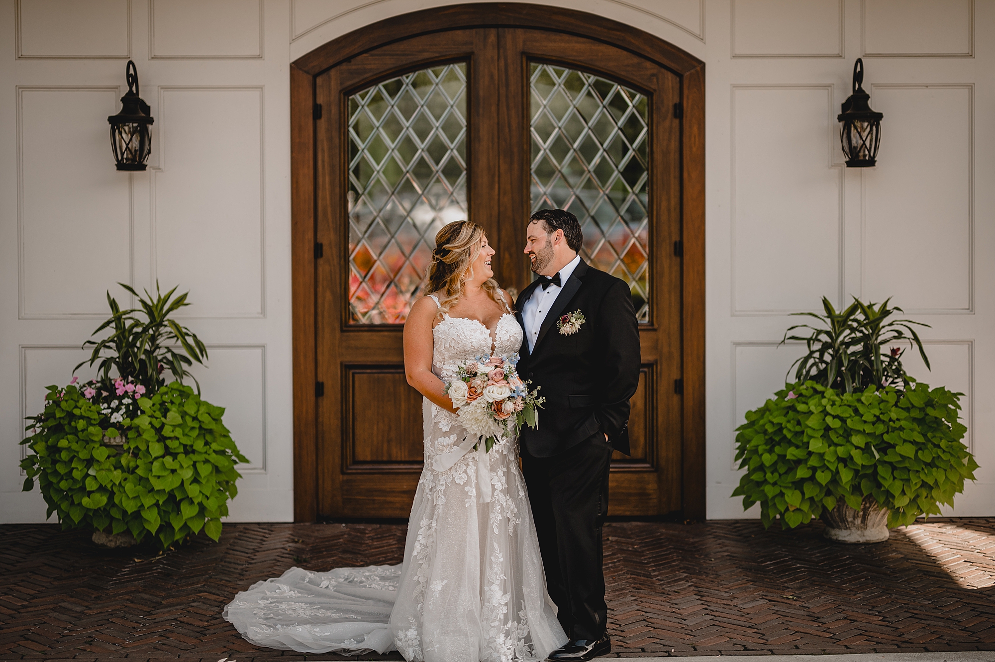 bride and groom hug in front of wooden doors at the Mill Lakeside Manor