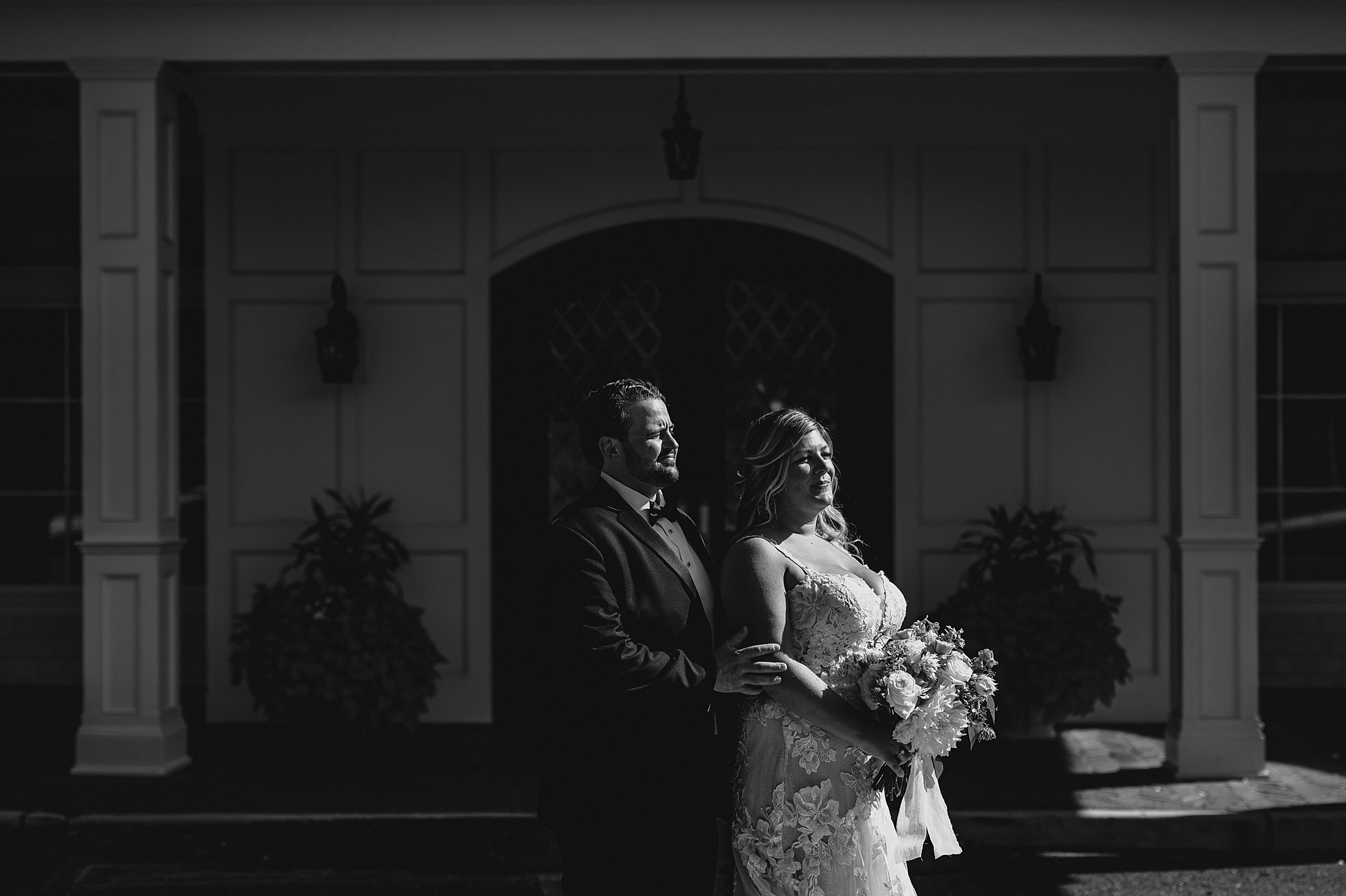 groom hugs bride from behind outside the Mill Lakeside Manor