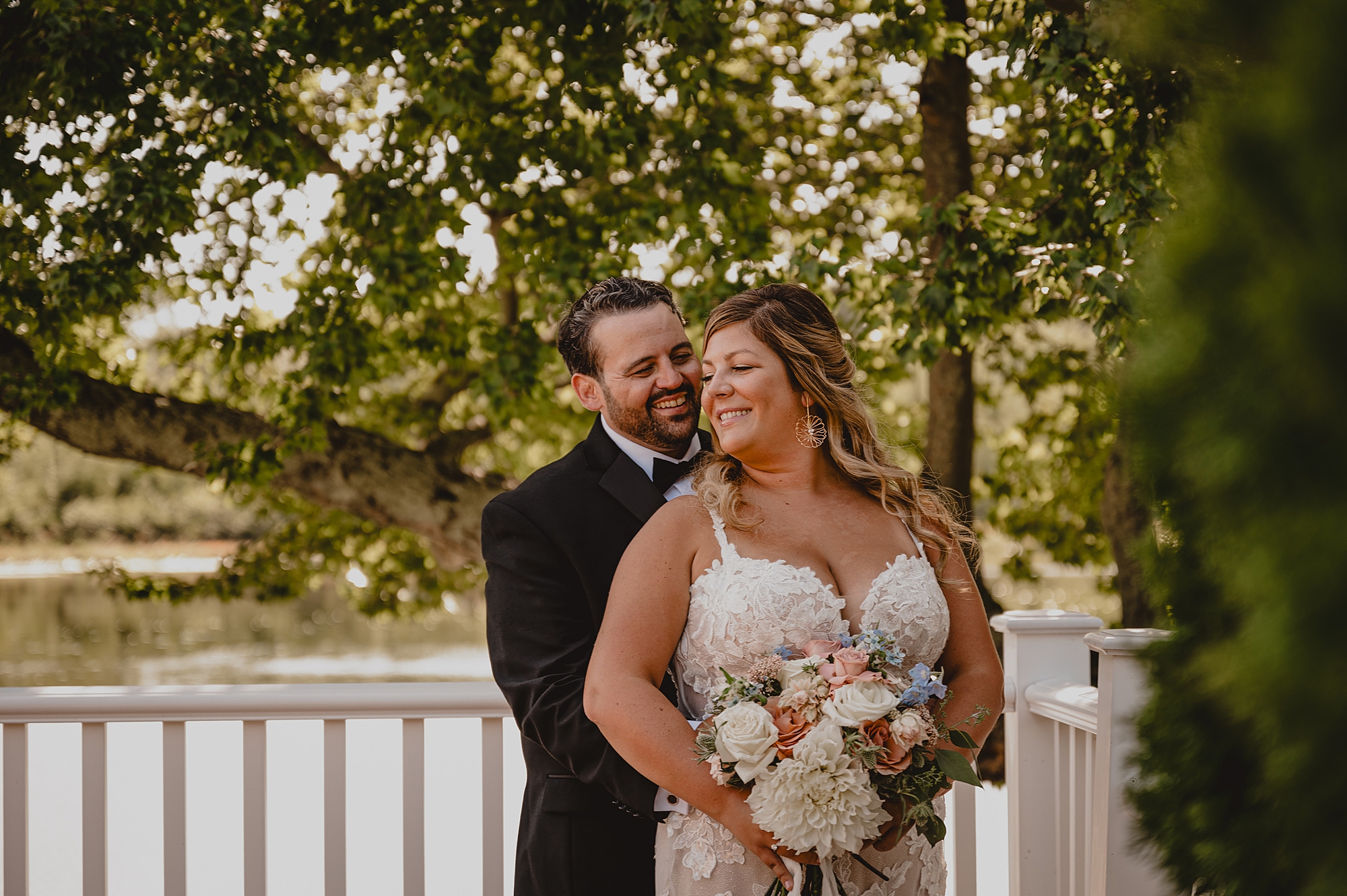 bride and groom hug on patio of the Mill Lakeside Manor