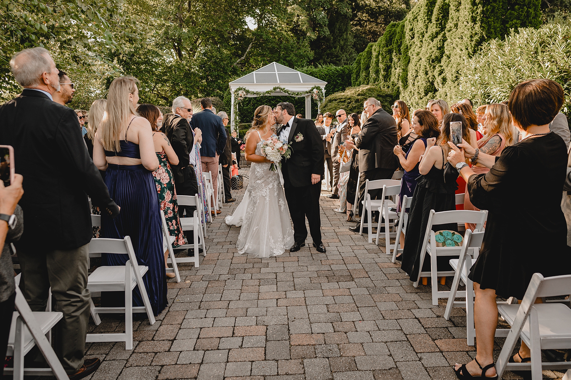 bride and groom kiss in aisle after ceremony at the Mill Lakeside Manor