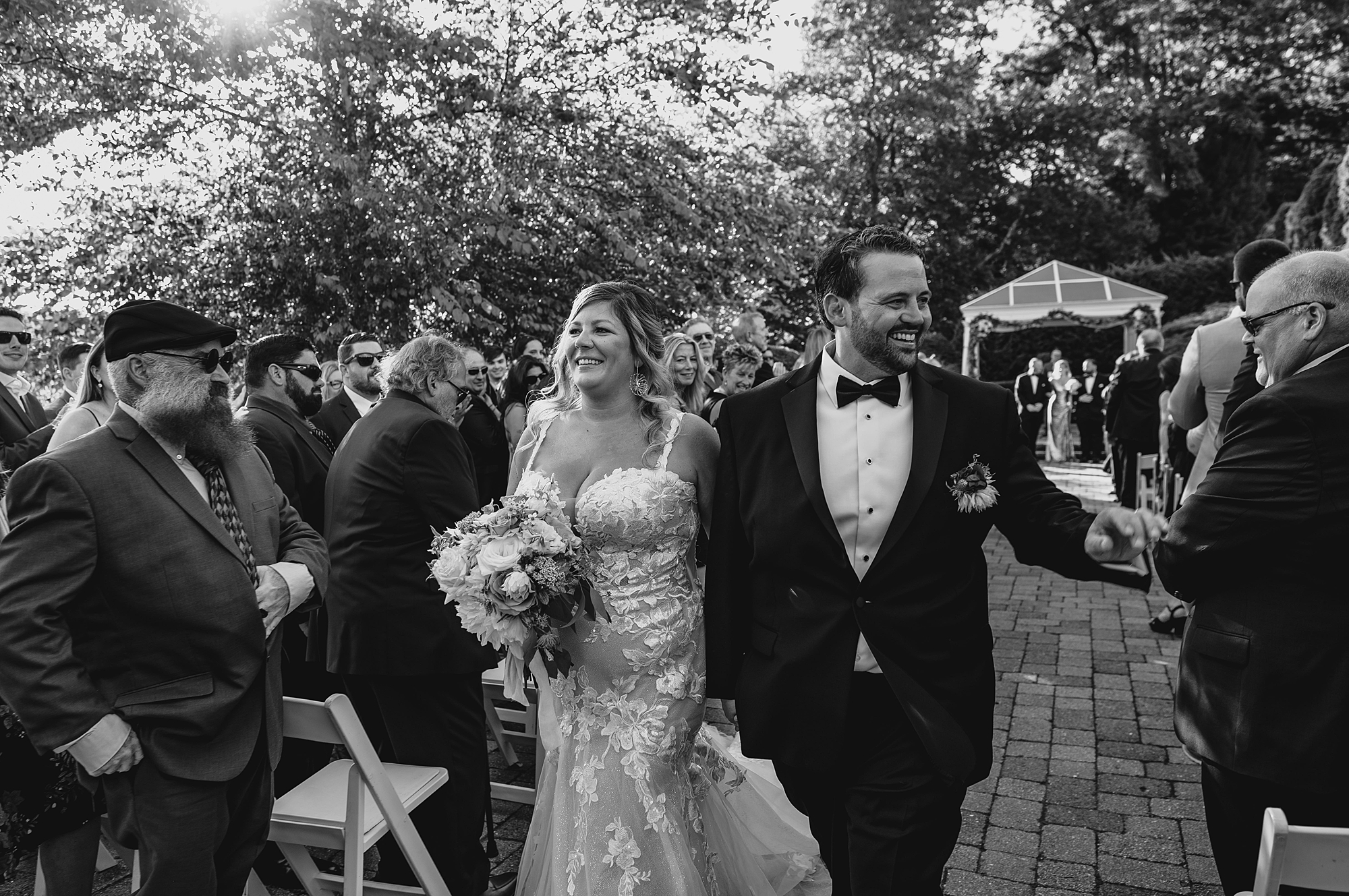 bride and groom grin walking up aisle after ceremony