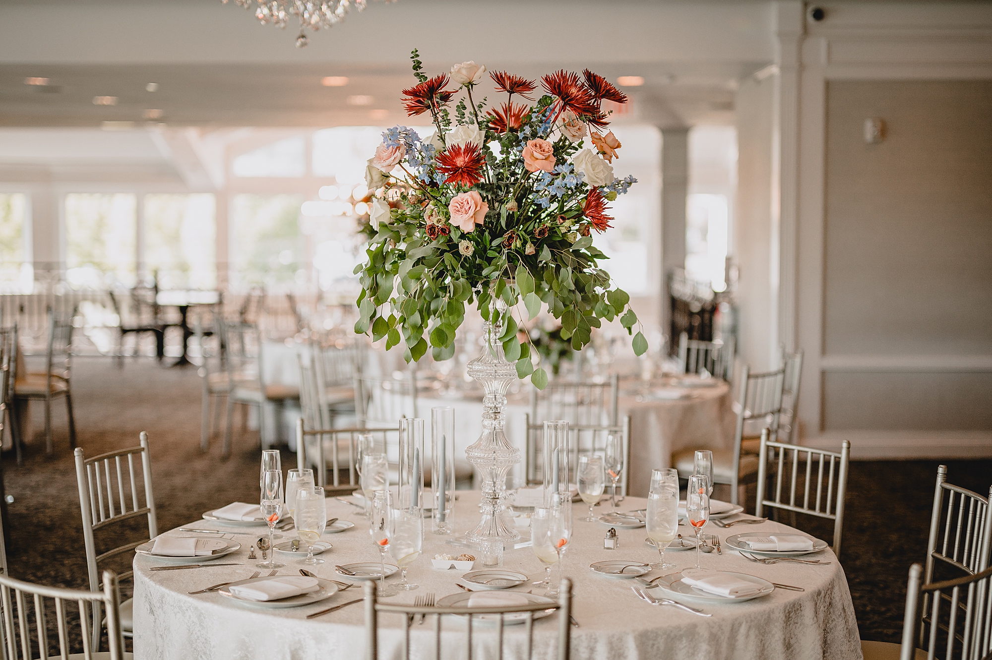 tall floral centerpiece with fall colored flowers at the Mill Lakeside Manor