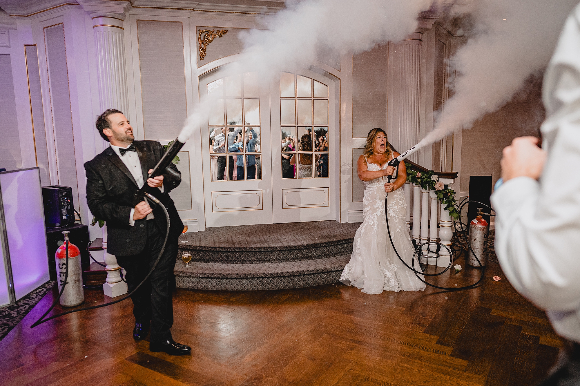 bride and groom shoot fog into reception