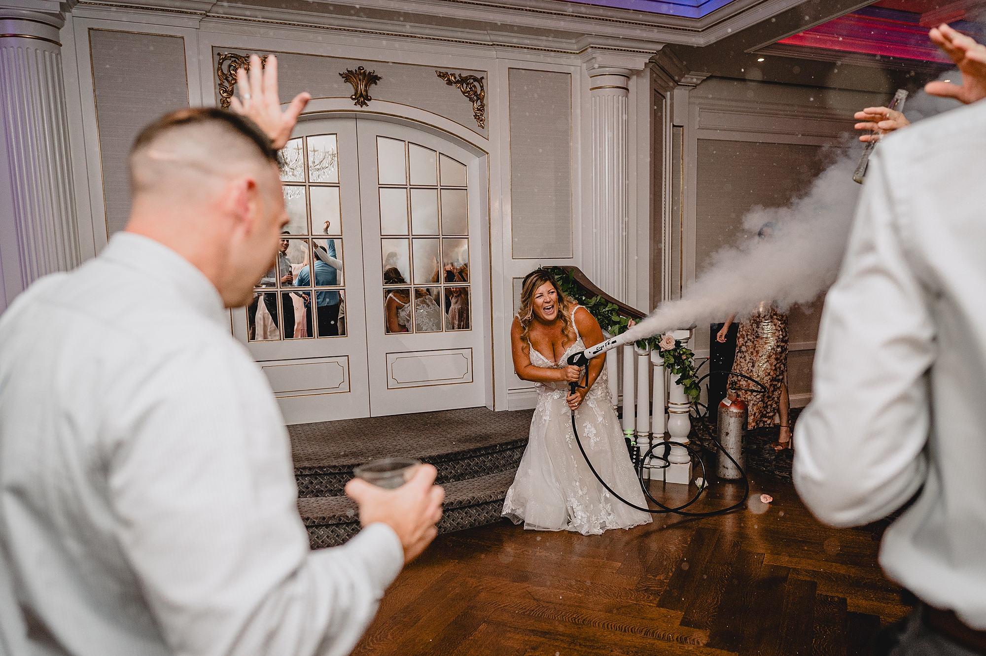 bride uses fog machine on dance floor