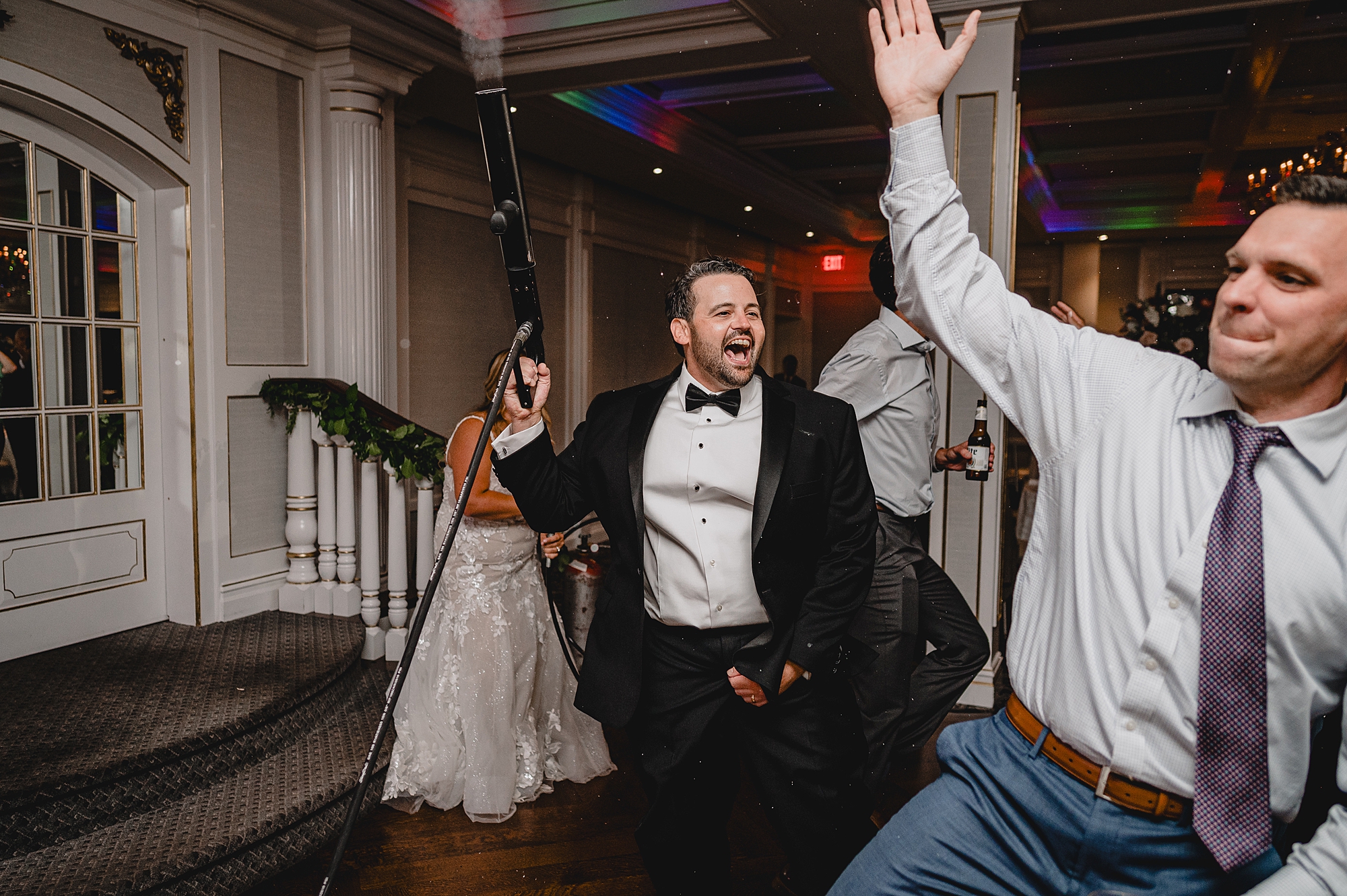 groom shoots fog into the air during Spring Lake NJ wedding reception