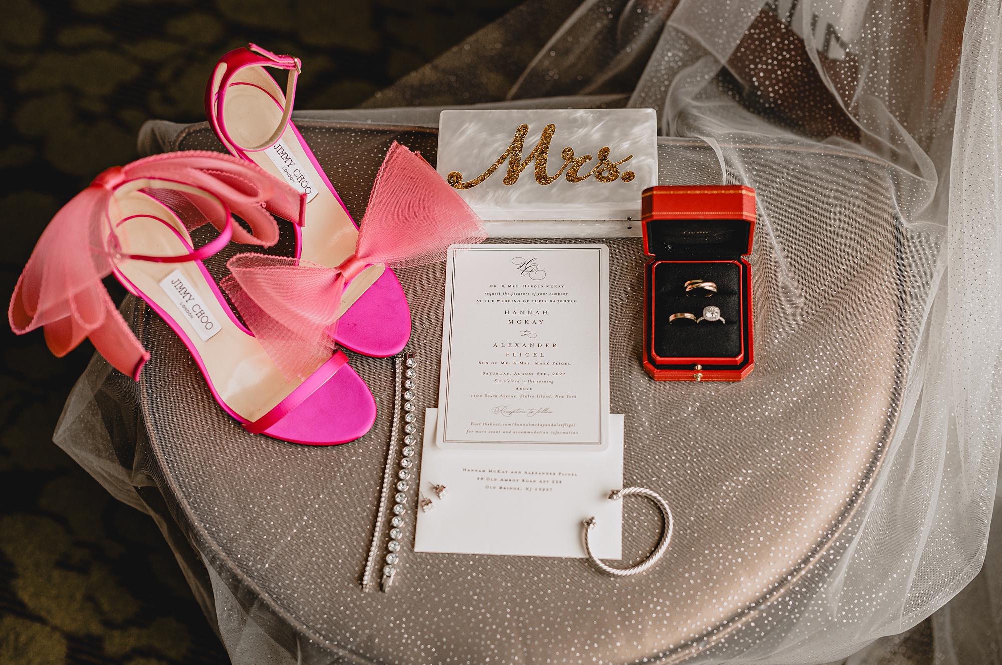 bride's pink shoes and jewelry on stool draped in veil