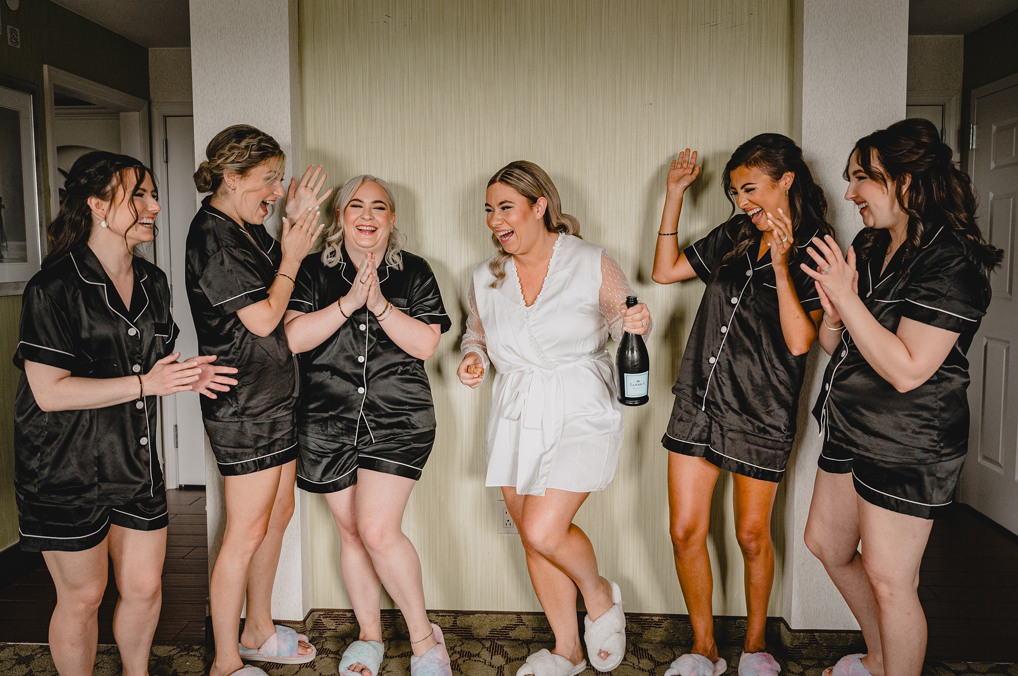 bride laughs with bridesmaids in matching pajamas