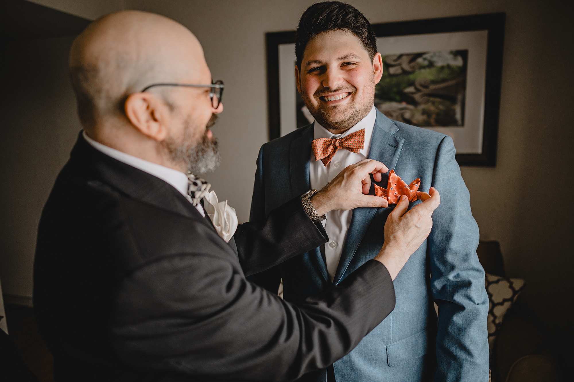 man puts orange pocket square in blue suit