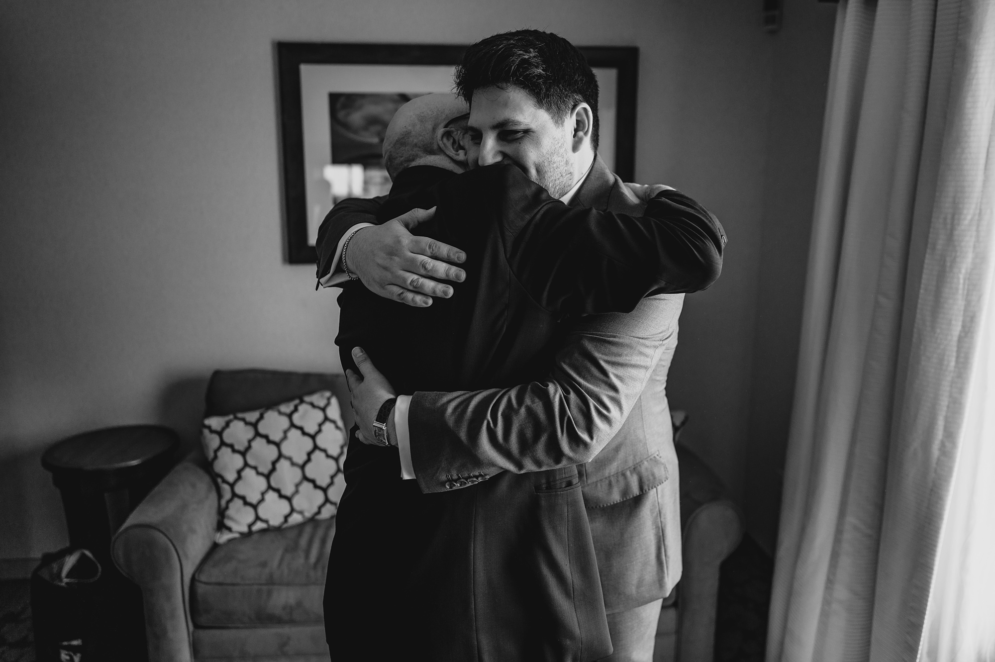man and dad hug during prep for wedding day