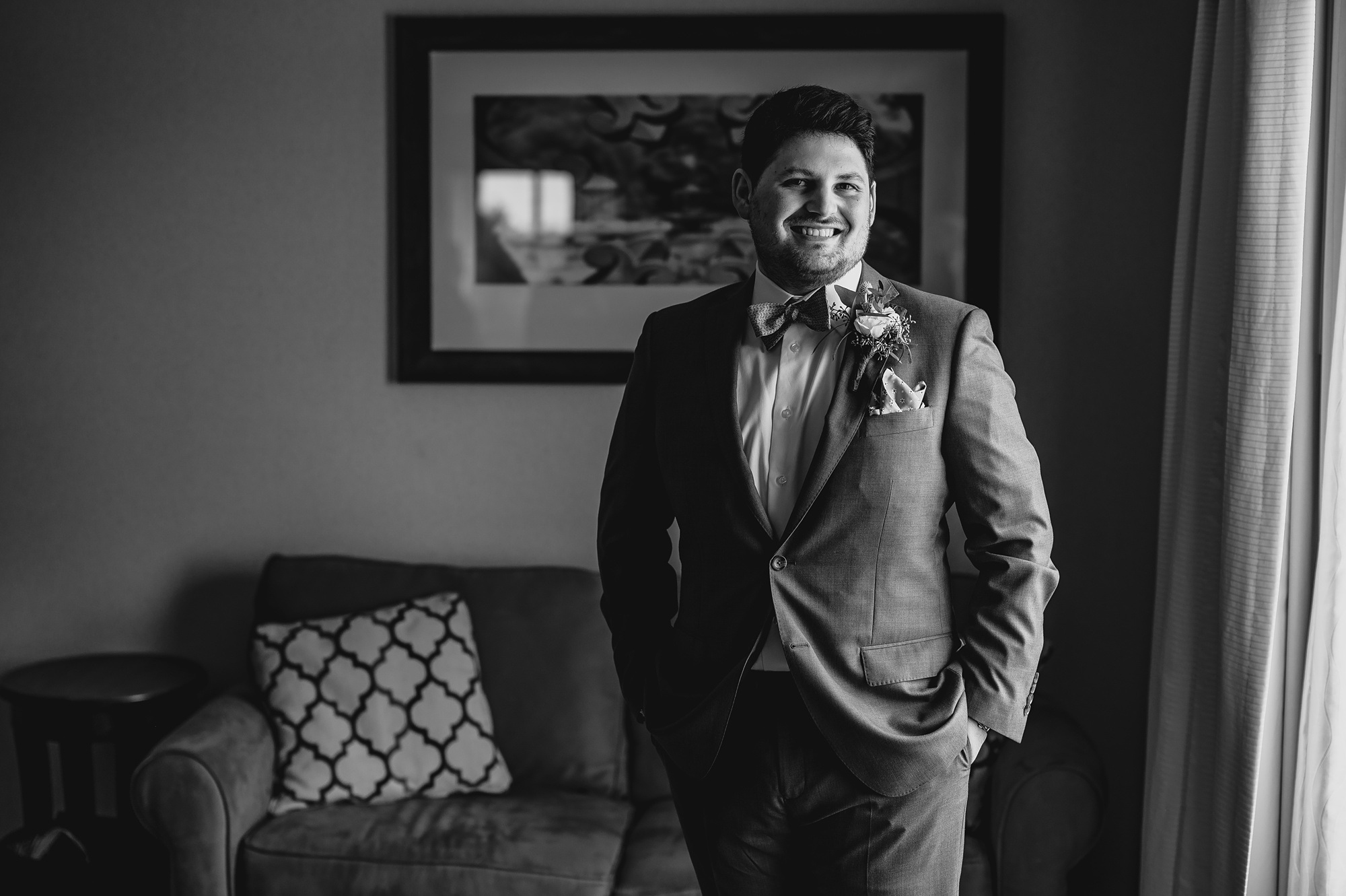 groom stands with hands in pocket during prep at Staten Island hotel