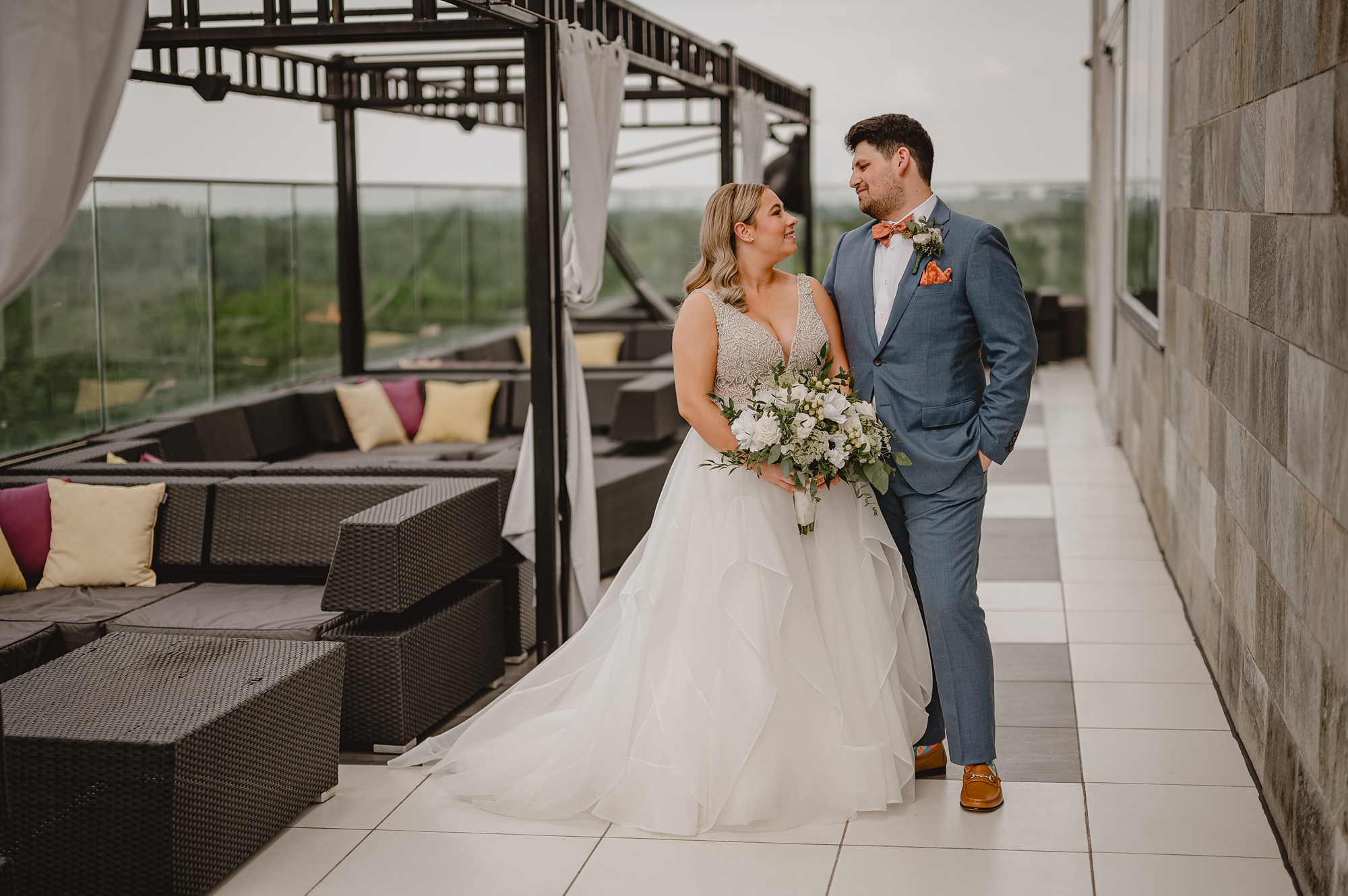 groom smiles at bride on patio of Above Staten Island