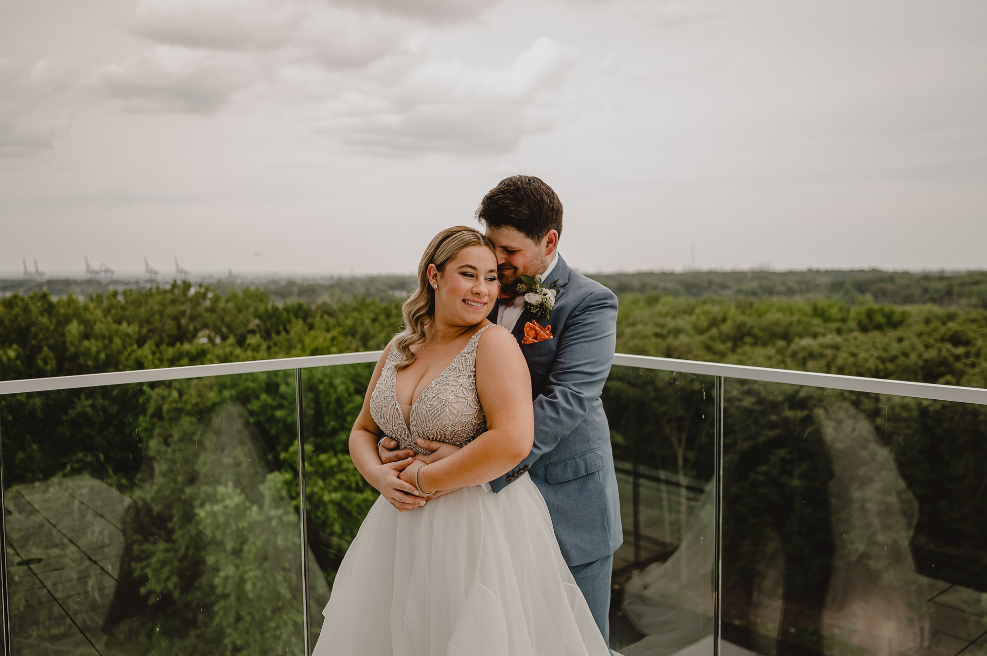 groom hugs bride hugs on rooftop during first look at Above Staten Island