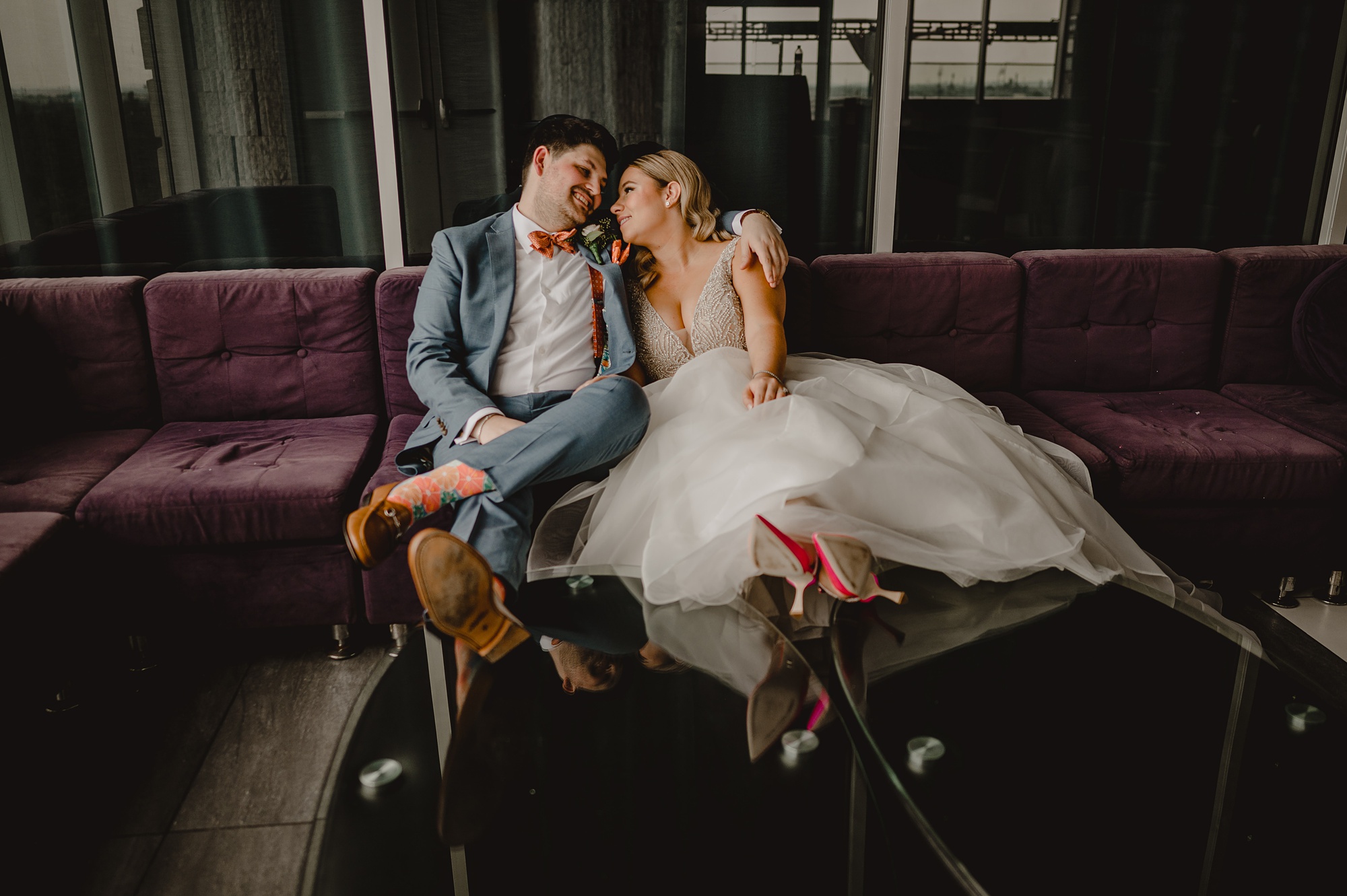 bride and groom sit on sofa together inside Above Staten Island