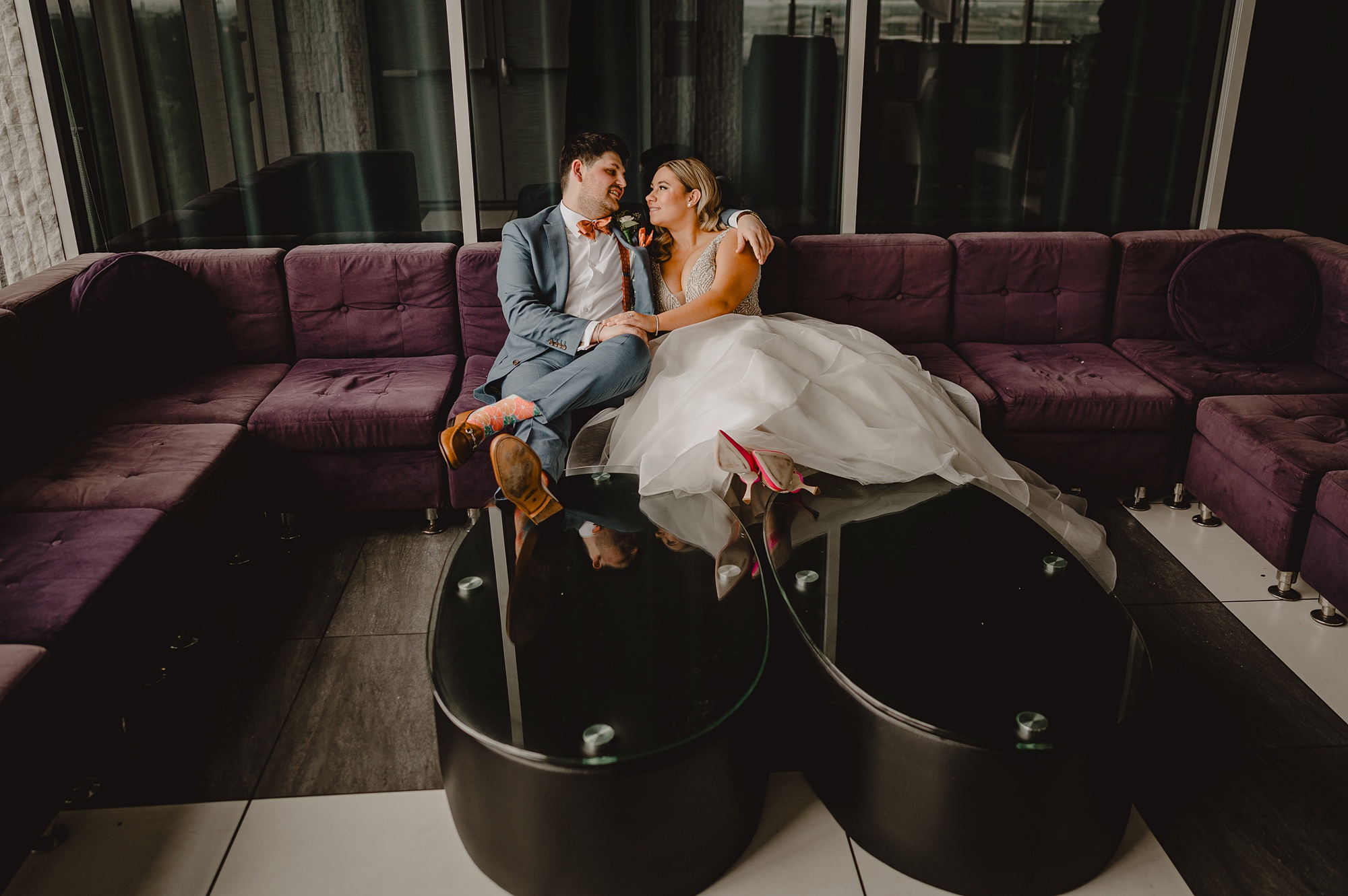 newlyweds sit on sofa snuggling during wedding portraits at Above Staten Island
