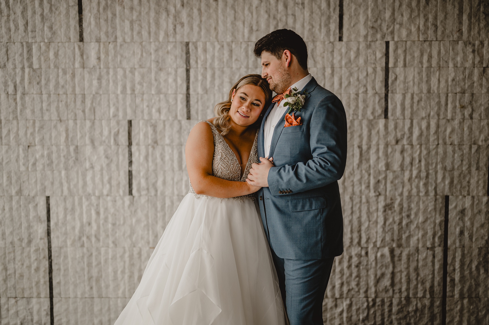bride leans on groom's chest during portraits in New York City