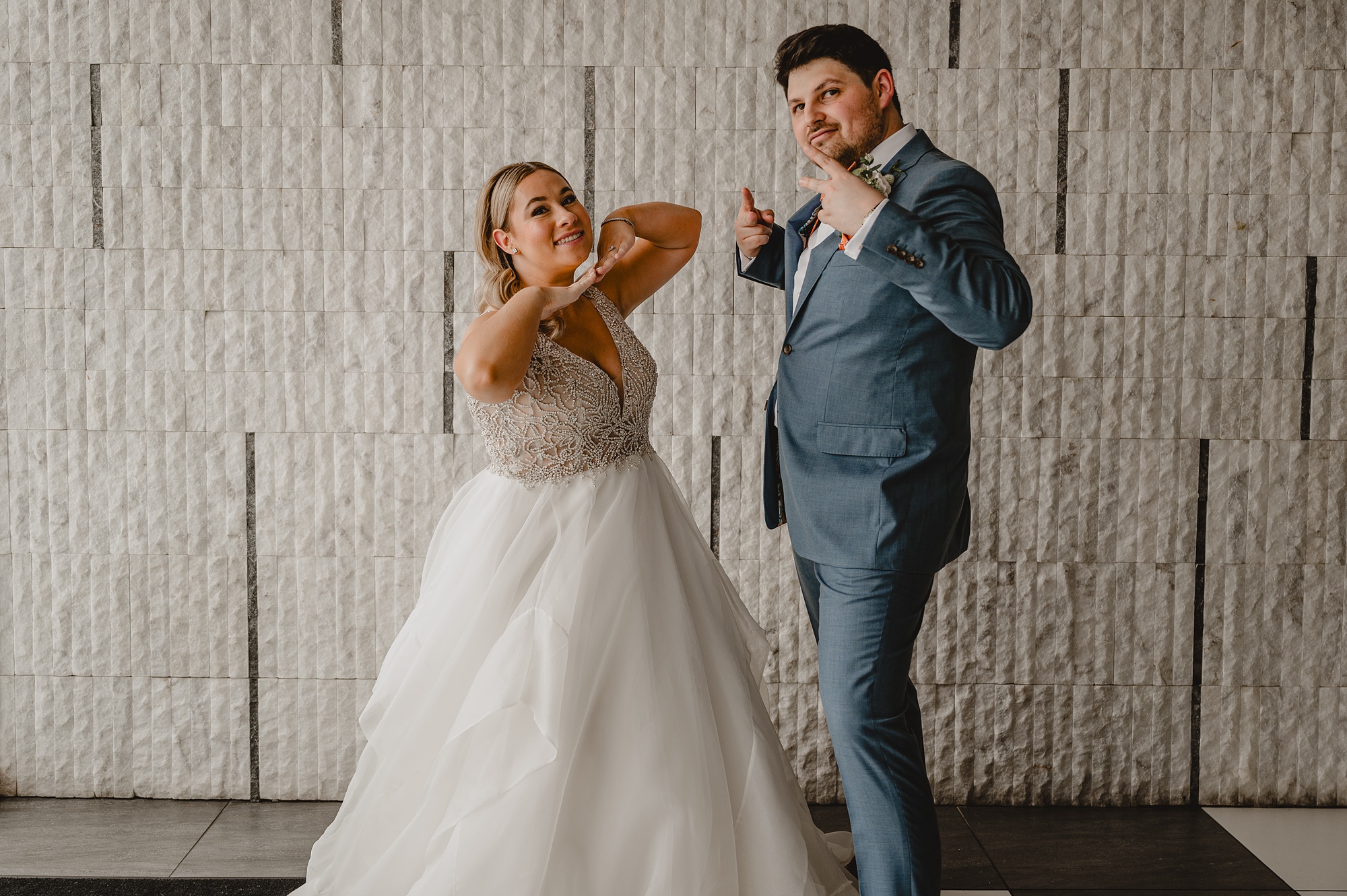 newlyweds dance in front of stone wall at Above Staten Island