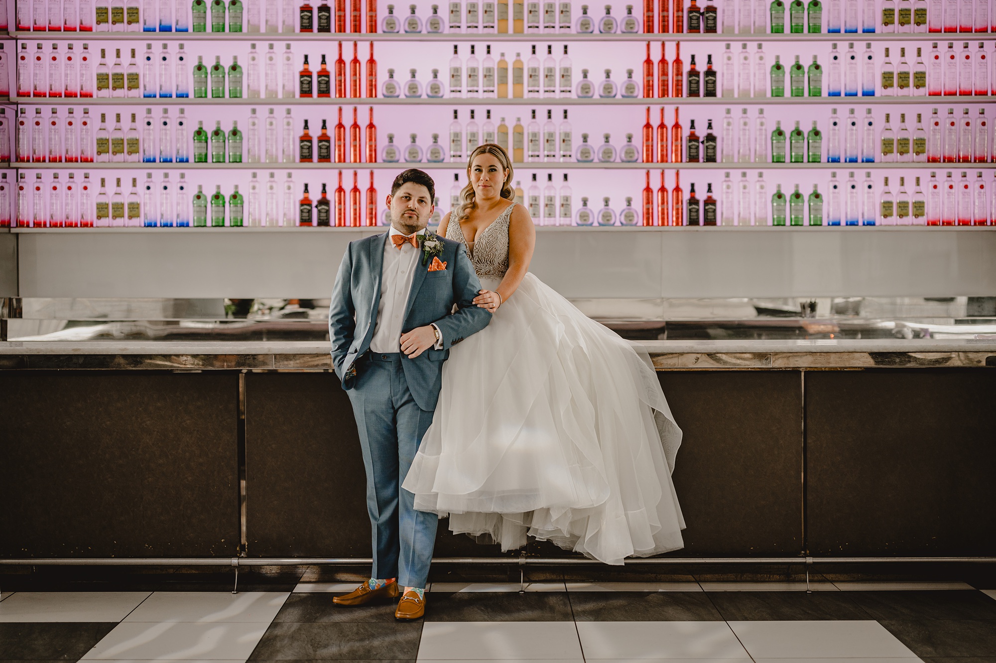 bride and groom sit on bar inside Above Staten Island