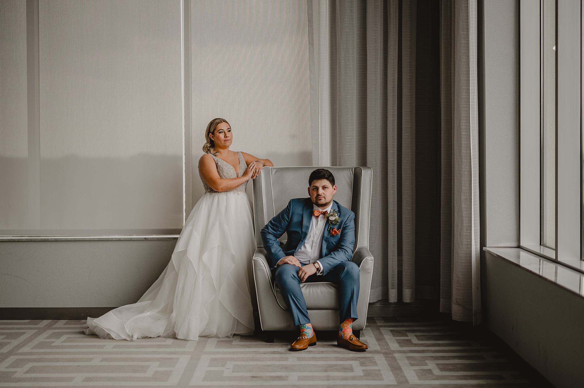 bride leans against chair in lobby of Above Staten Island