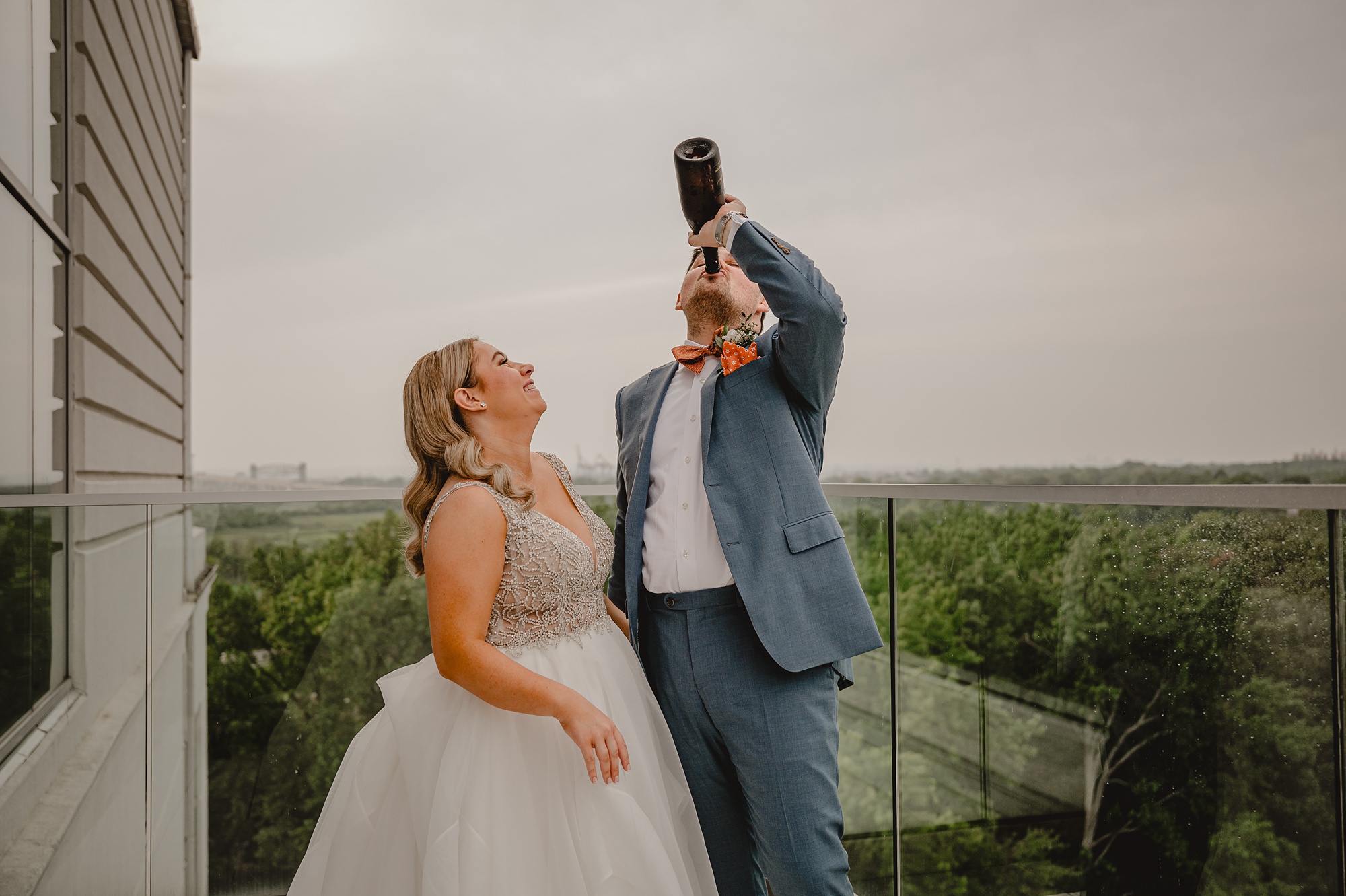 groom drips bottle of champagne on rooftop patio at Above Staten Island