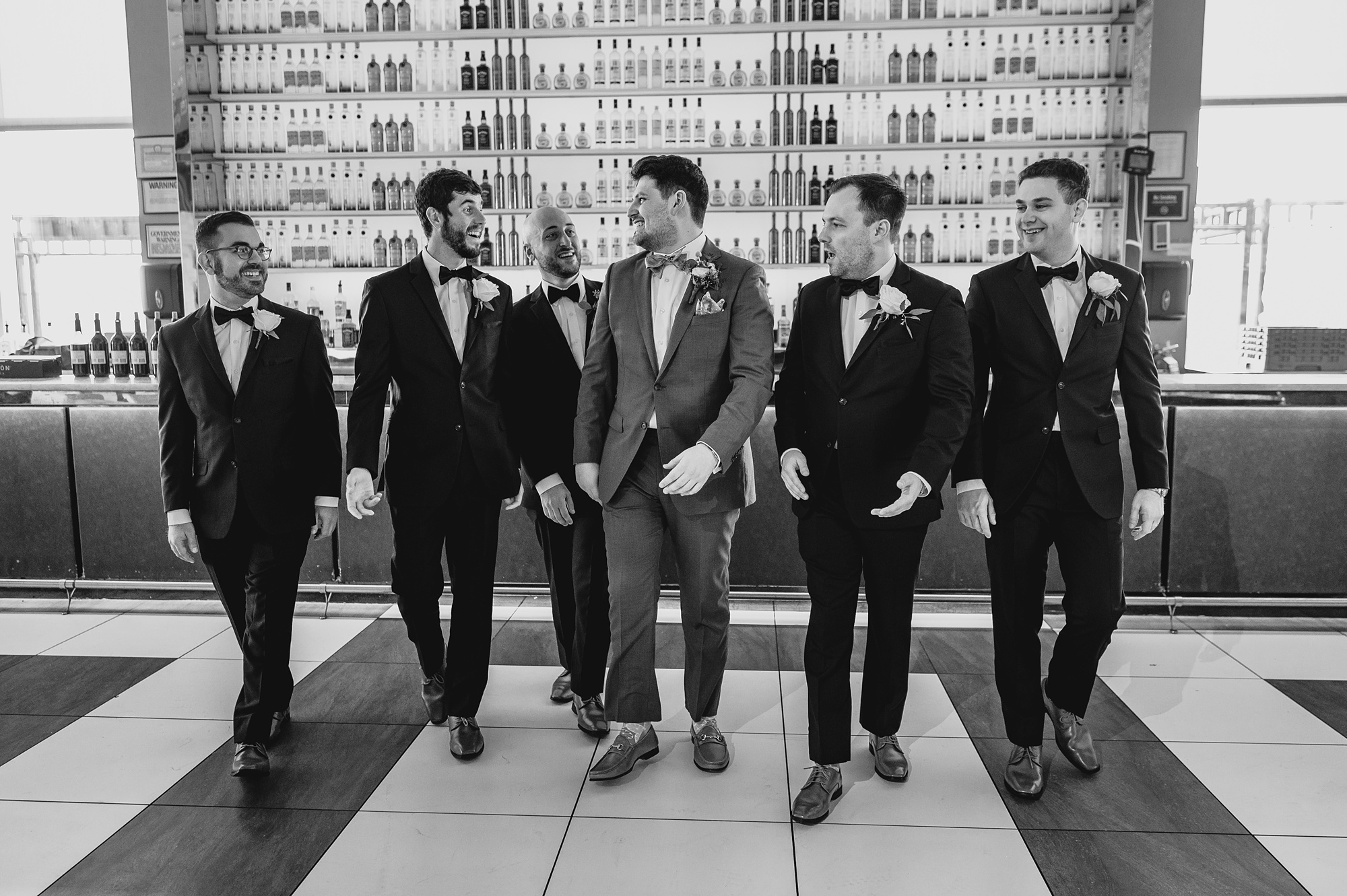 groom walks with groomsmen on rooftop patio at Above Staten Island