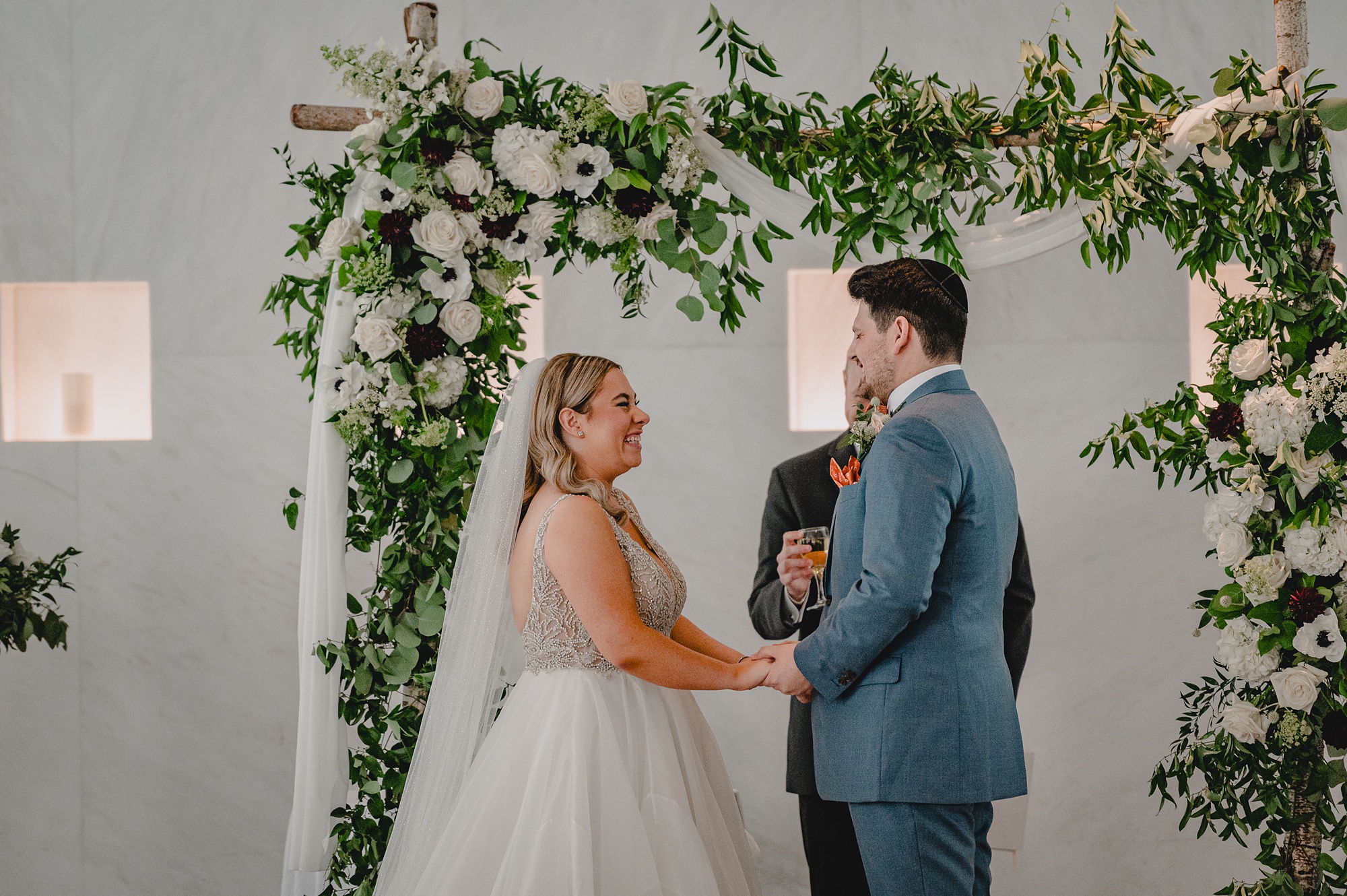bride and groom hold hands during wedding ceremony at Above Staten Island
