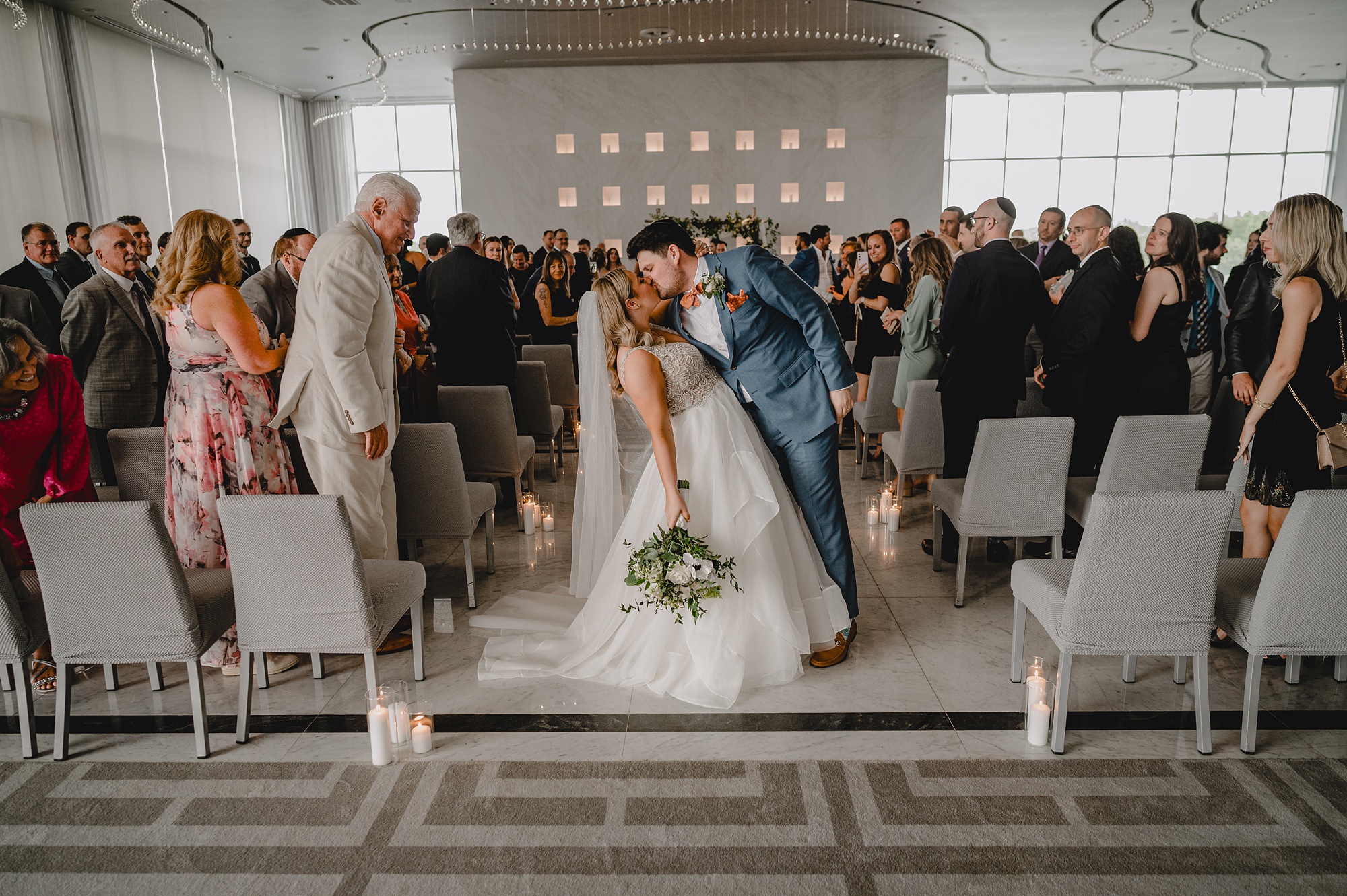 newlyweds kiss in aisle after wedding ceremony at Above Staten Island