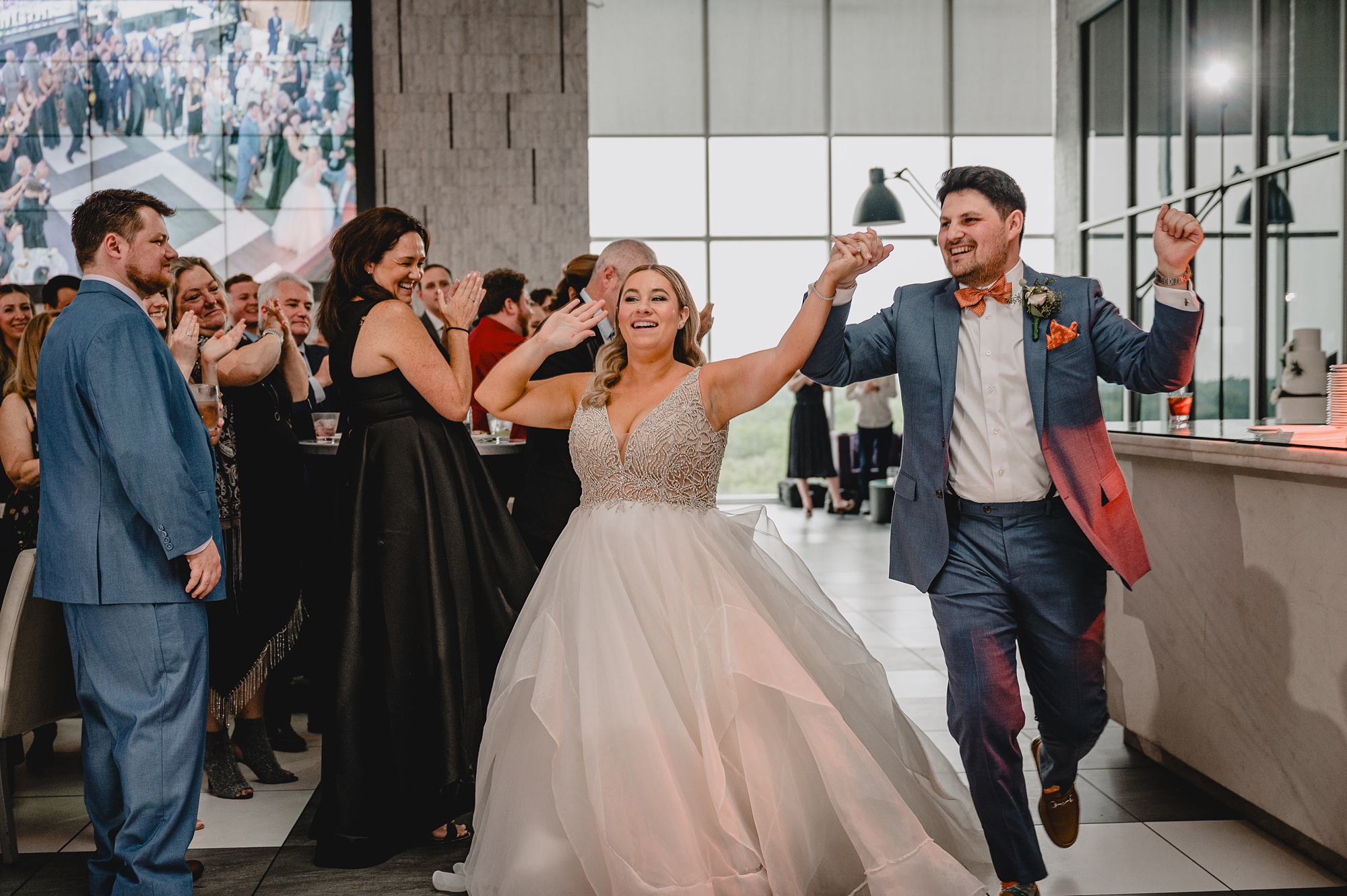 newlyweds cheer walking into reception at Above Staten Island