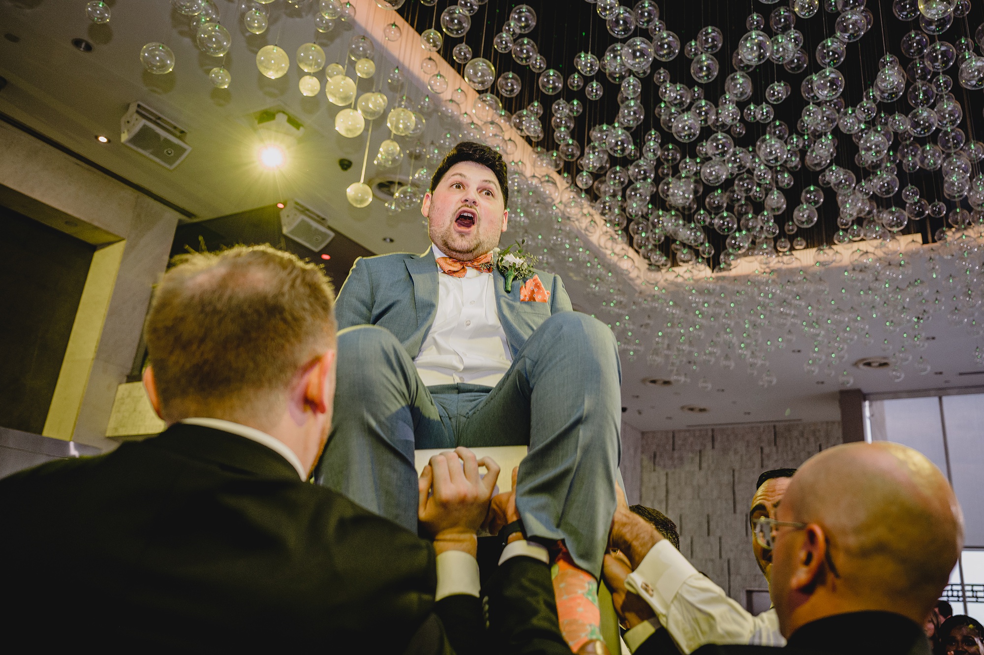 guests lift up groom during hora at Above Staten Island