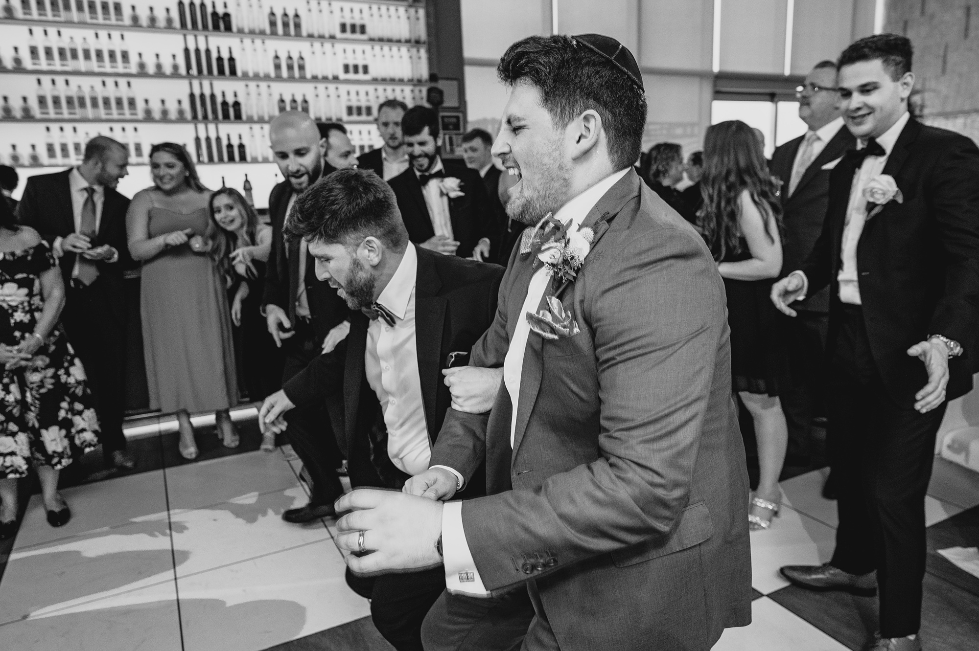 groom laughs dancing with guests