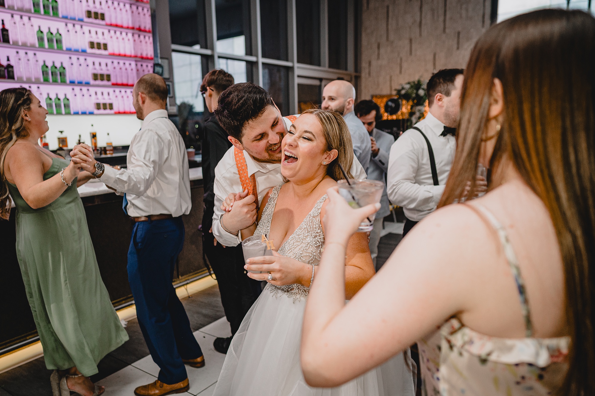 groom hugs bride from behind kissing her cheek