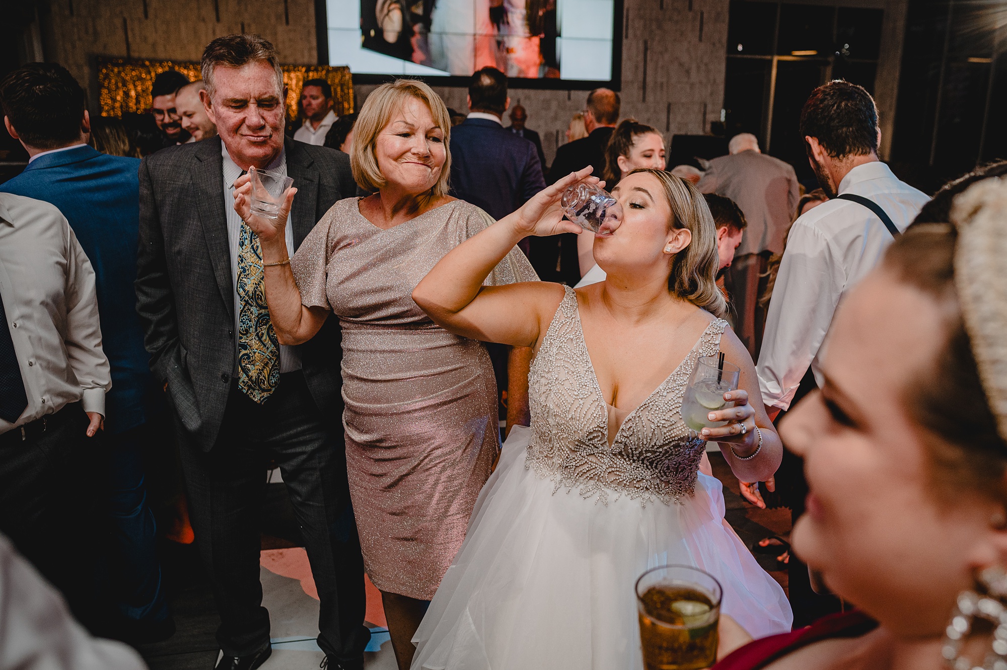bride dances and takes a drink on dance floor