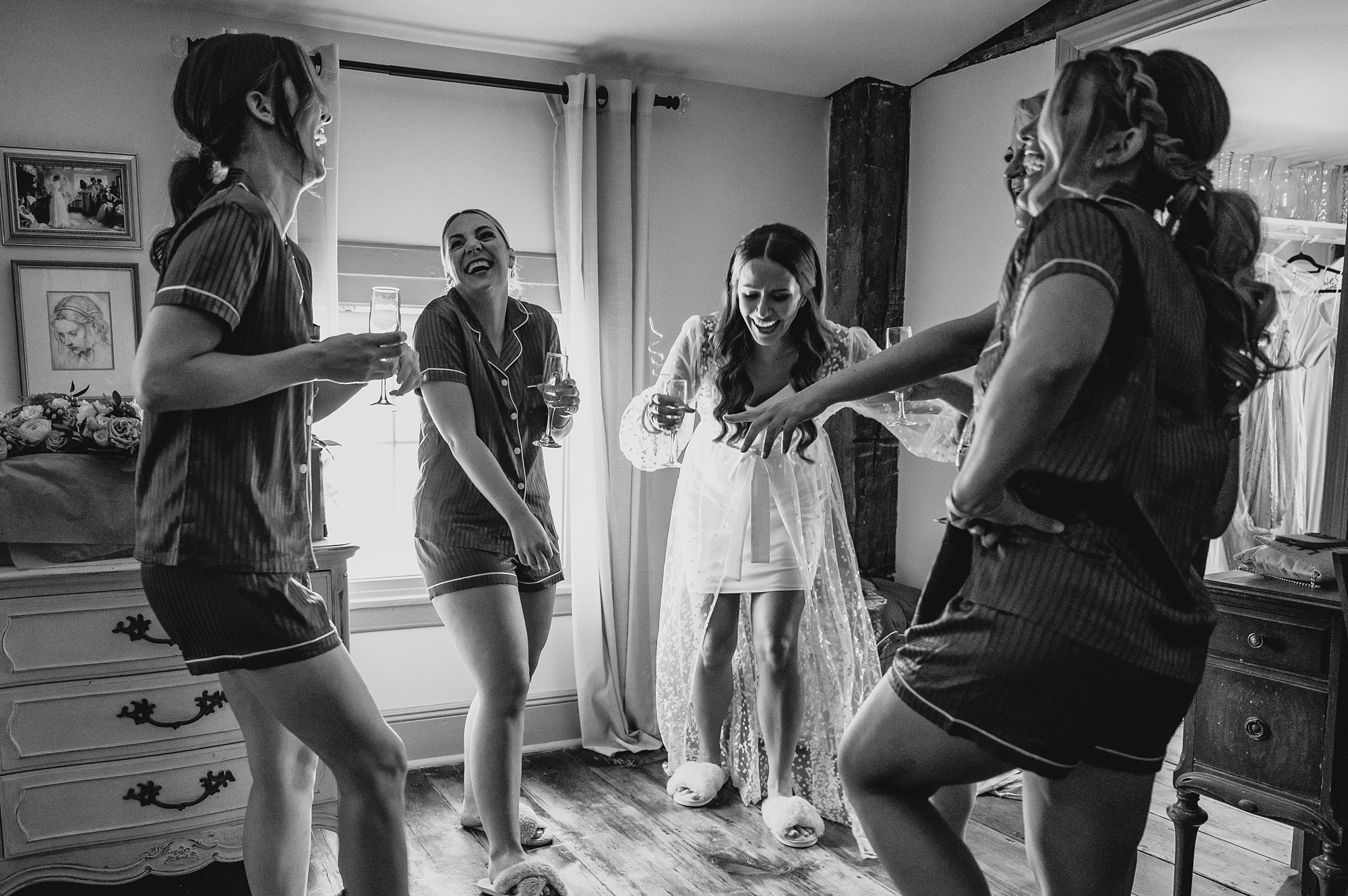 bride pours champagne for bridesmaids in suite at David's Country Inn