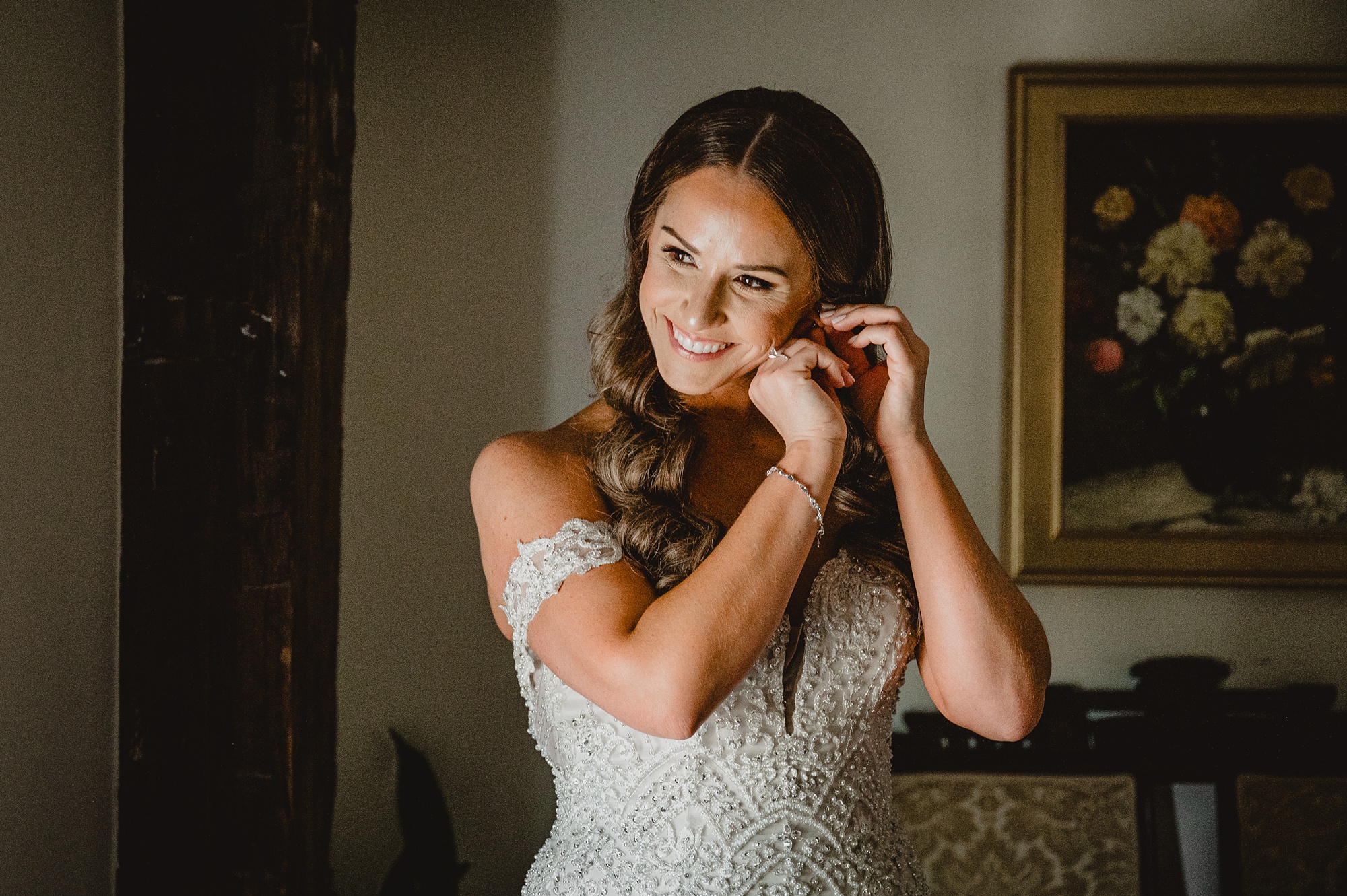 bride puts on earrings during prep at David's Country Inn