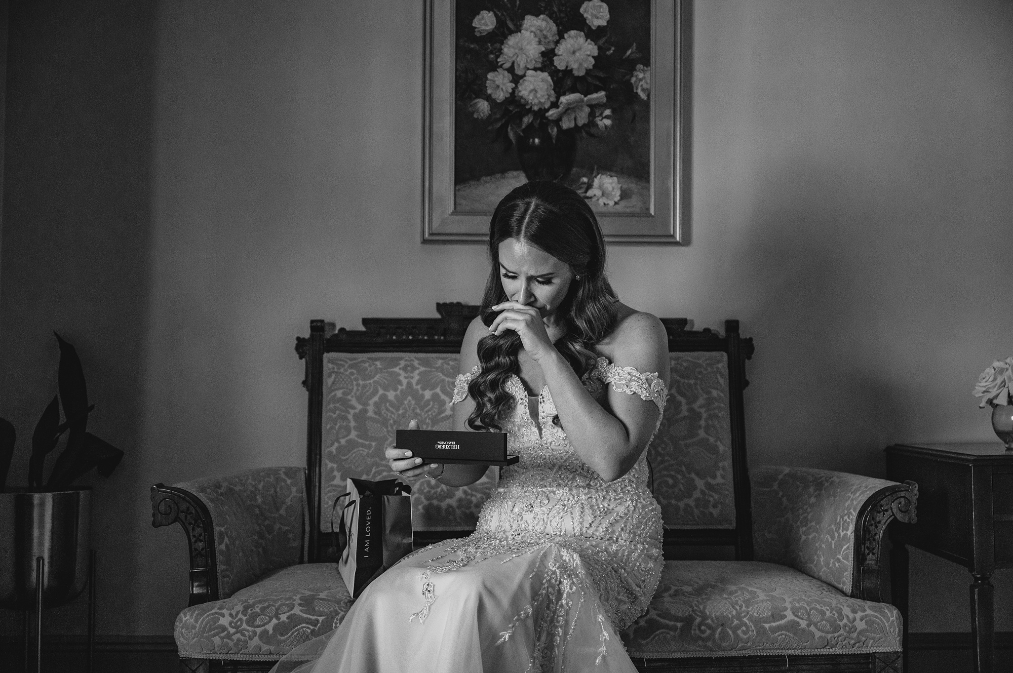bride cries opening gifts on bed during NJ wedding day prep