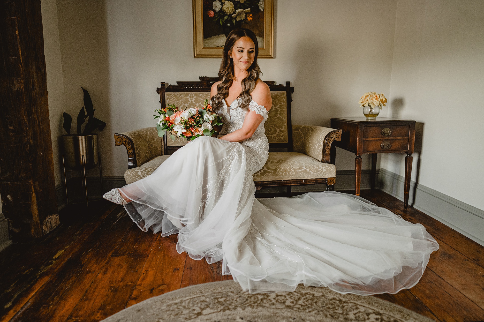 bride sits on vintage couch at David's Country Inn in wedding gown