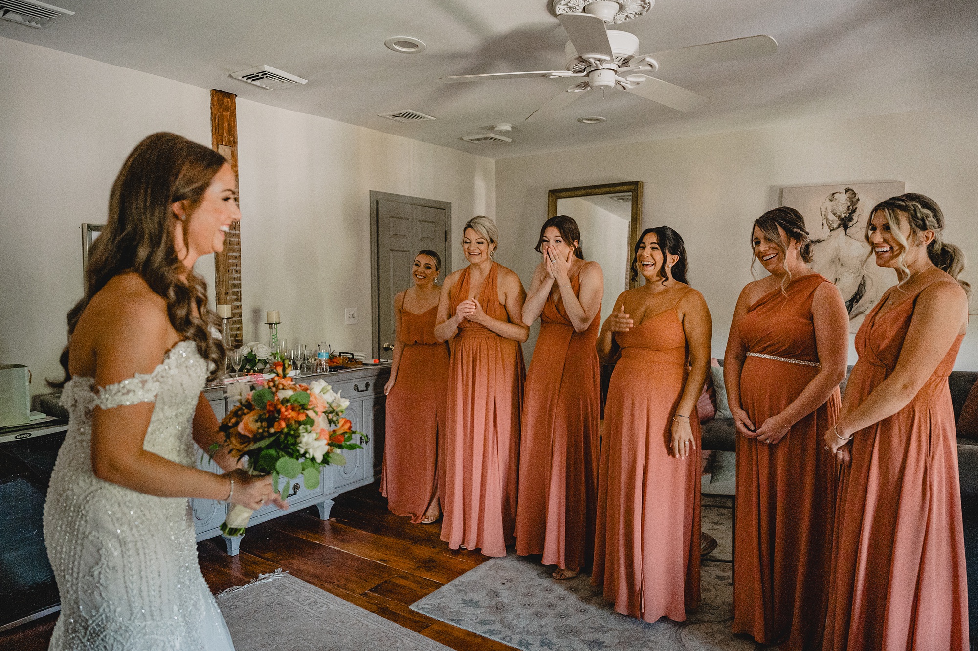 bridesmaid in burnt orange gowns react to bride during first look