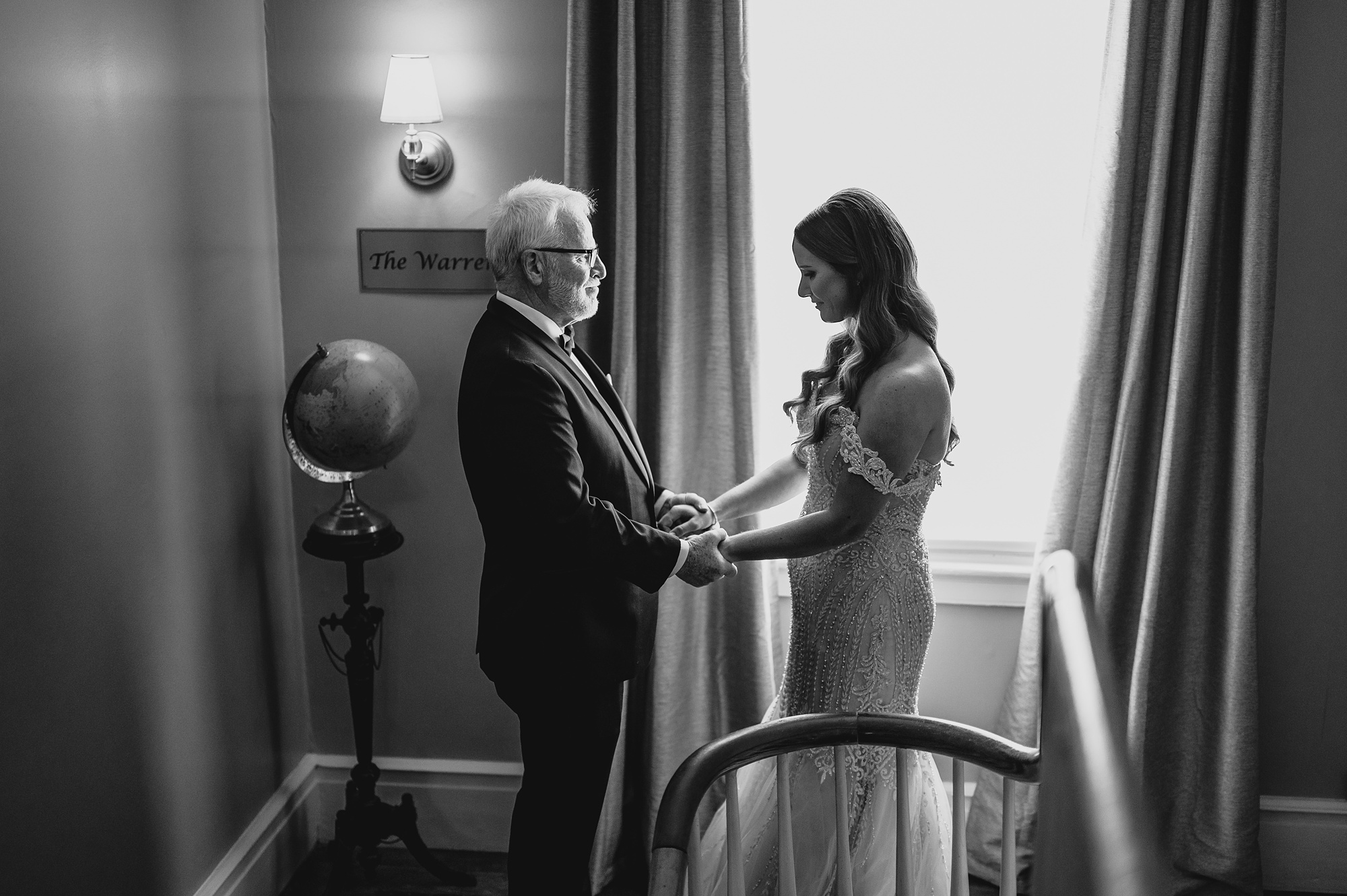 bride and dad hold hands during first look in staircase at David's Country Inn