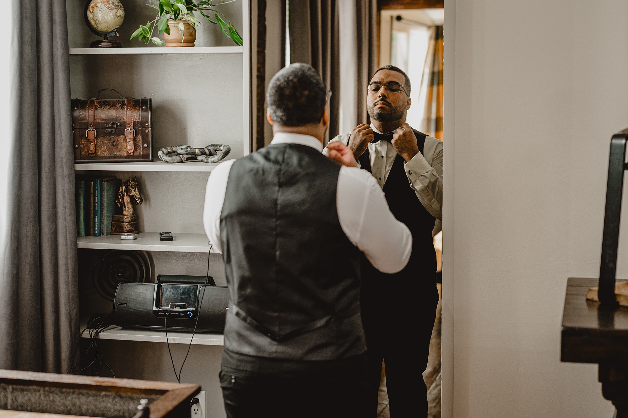 groom adjusts bow tie during wedding day prep at David's Country Inn