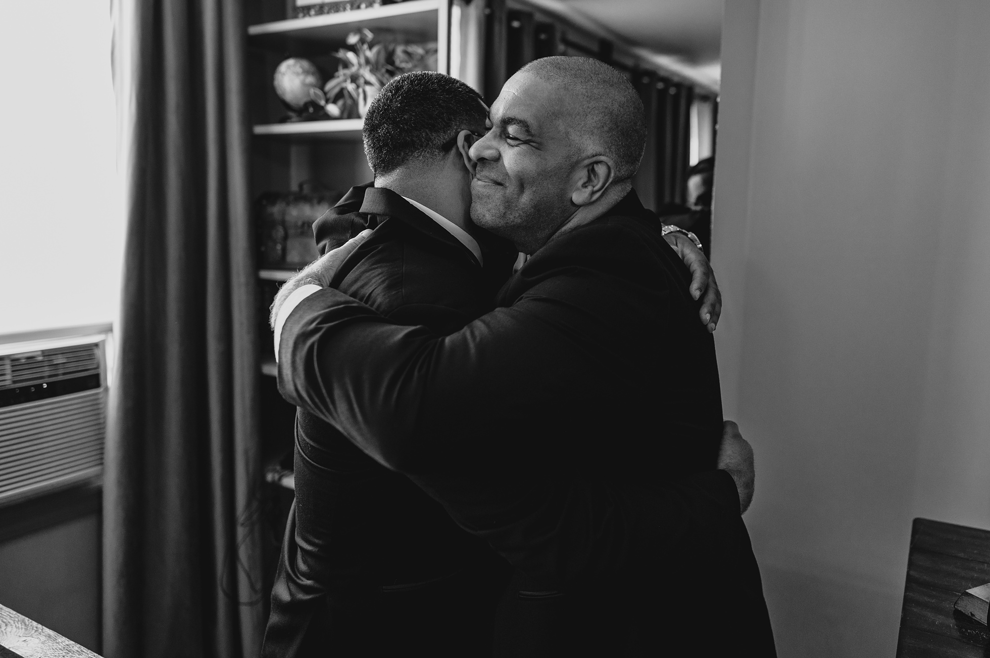 groom hugs groomsmen during prep for wedding day