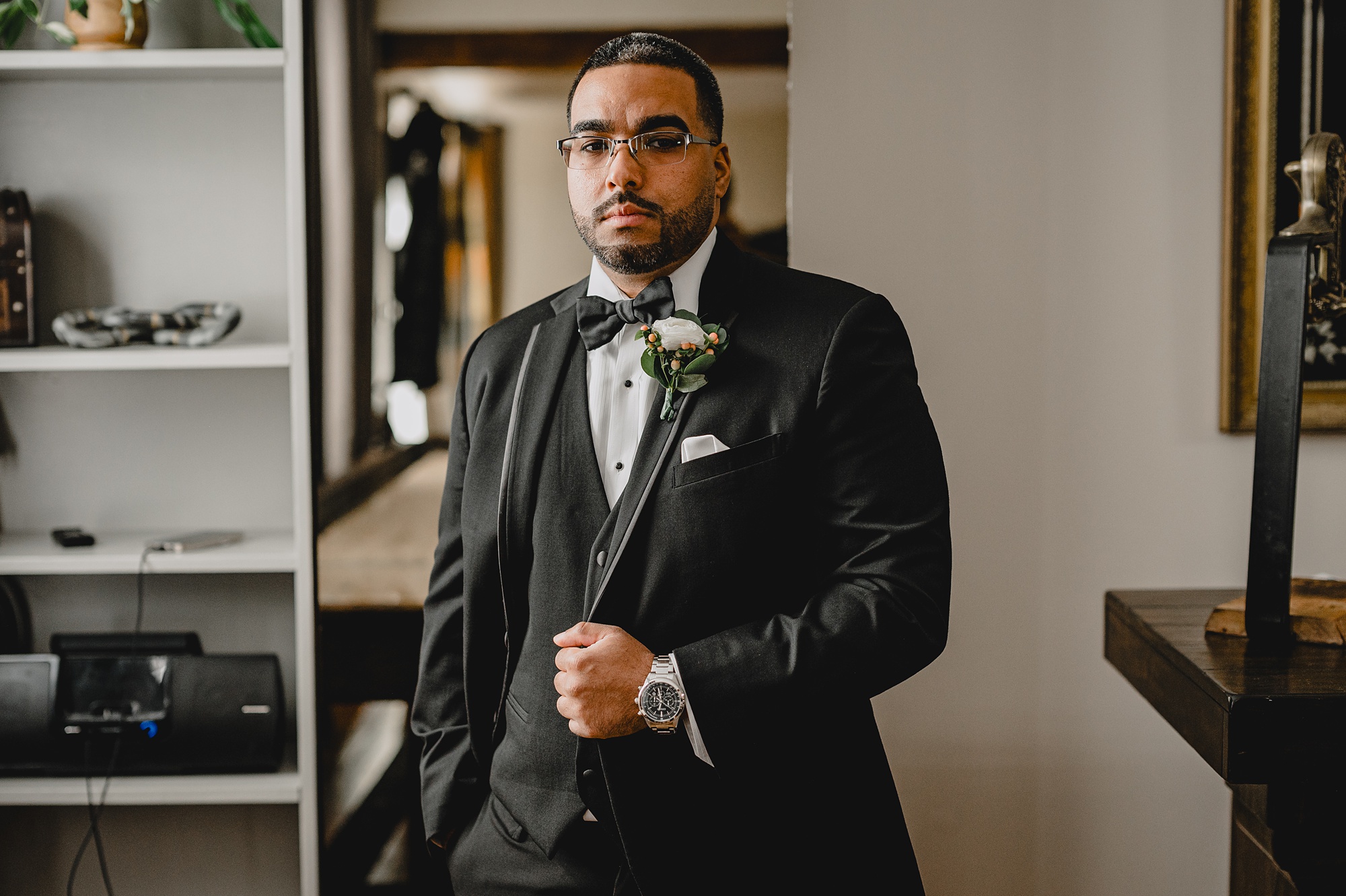 groom stands holding lapel of black suit at David's Country Inn