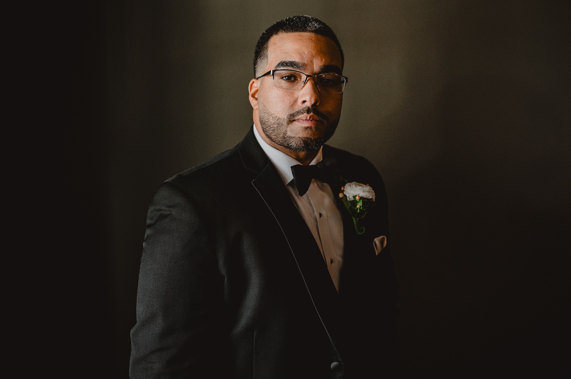 portrait of groom in front of green wall at David's Country Inn